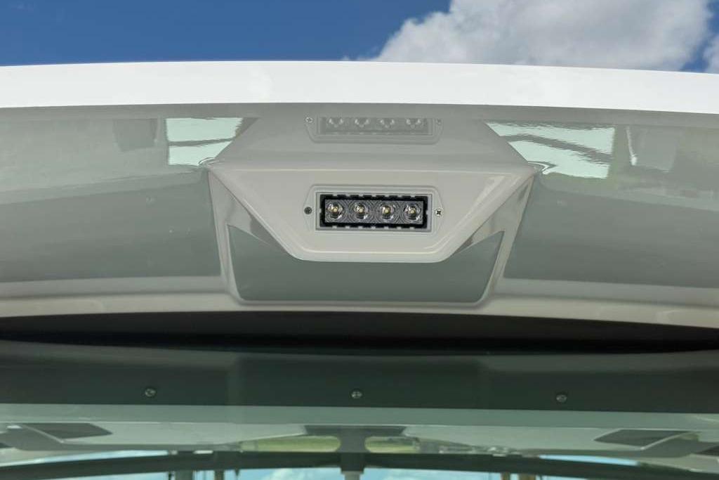 LED light fixture on 2026 Monterey Elite 30 OB boat against blue sky.