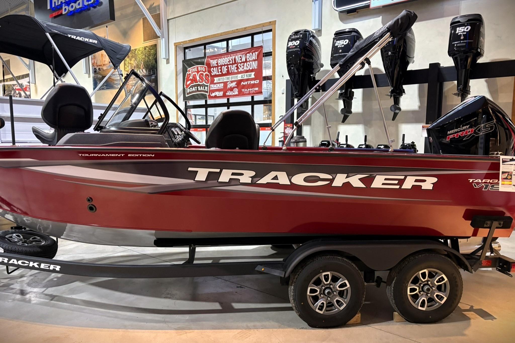 2025 Tracker Targa V-19 WT boat on display, featuring a sleek red design and dual axle trailer.