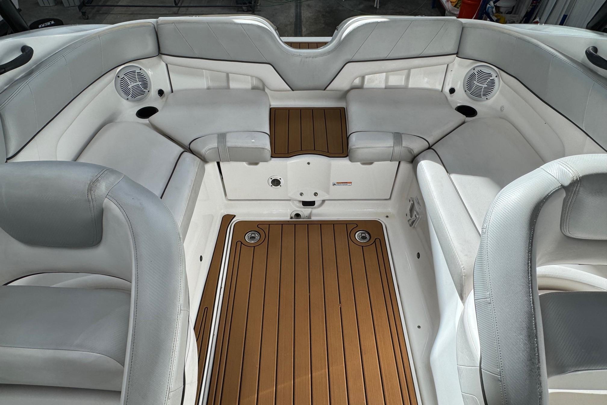Interior of 2012 Yamaha SX210 boat with cushioned seating and teak-style flooring.