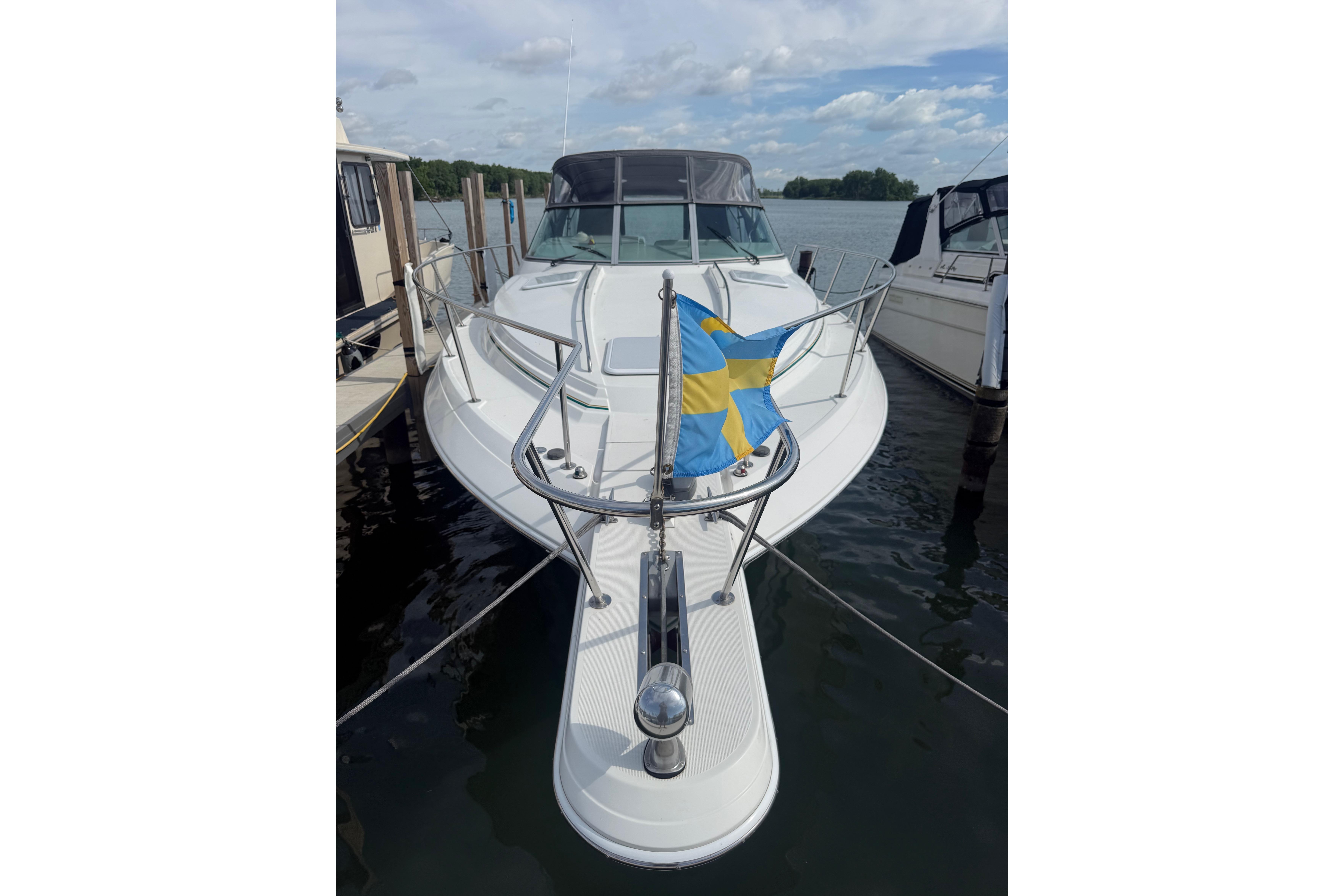 1999 Formula 34 Performance Cruiser docked with Swedish flag, under a partly cloudy sky.
