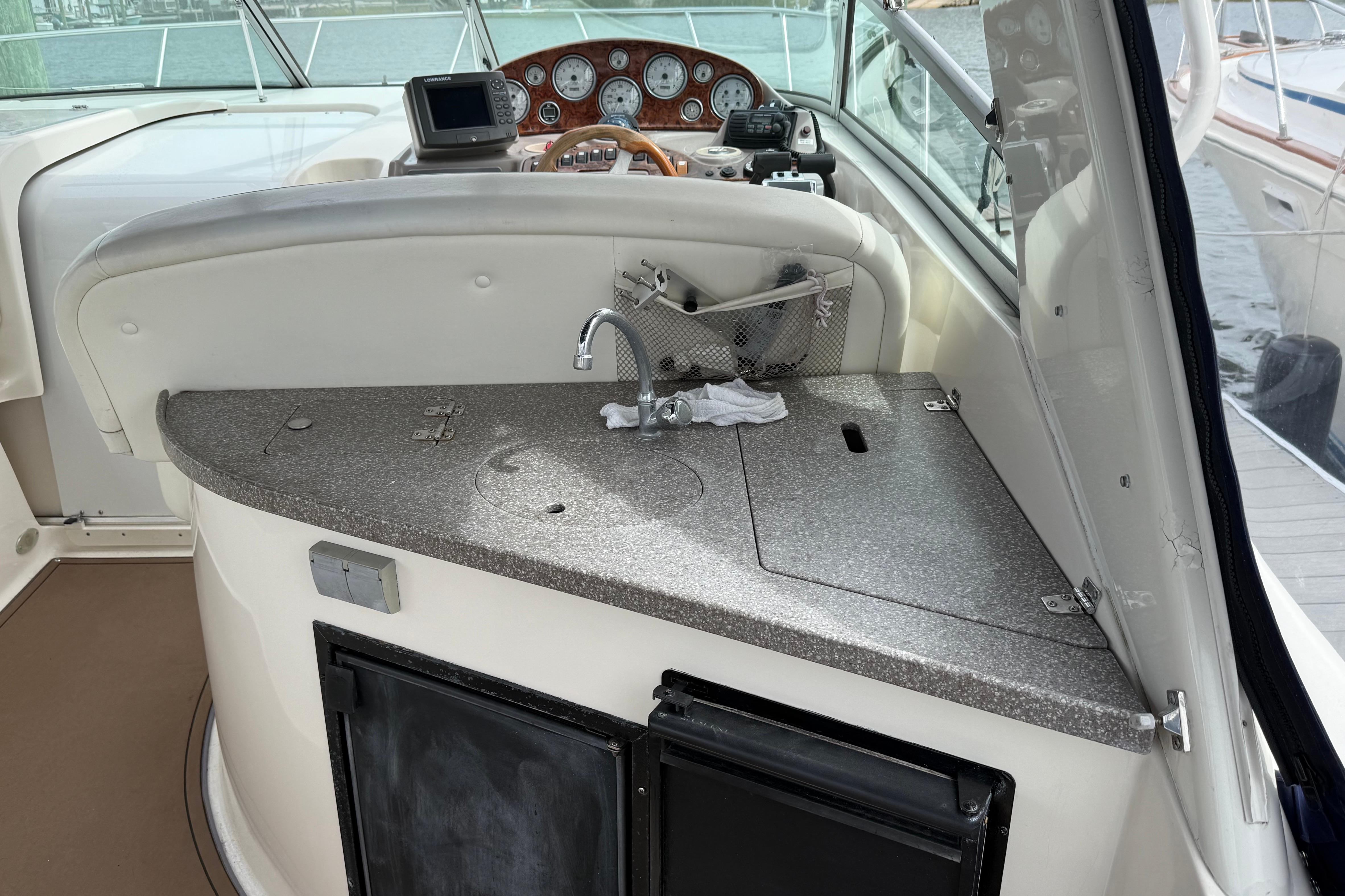 2004 Rinker 342 boat interior with helm, sink, and control panel.