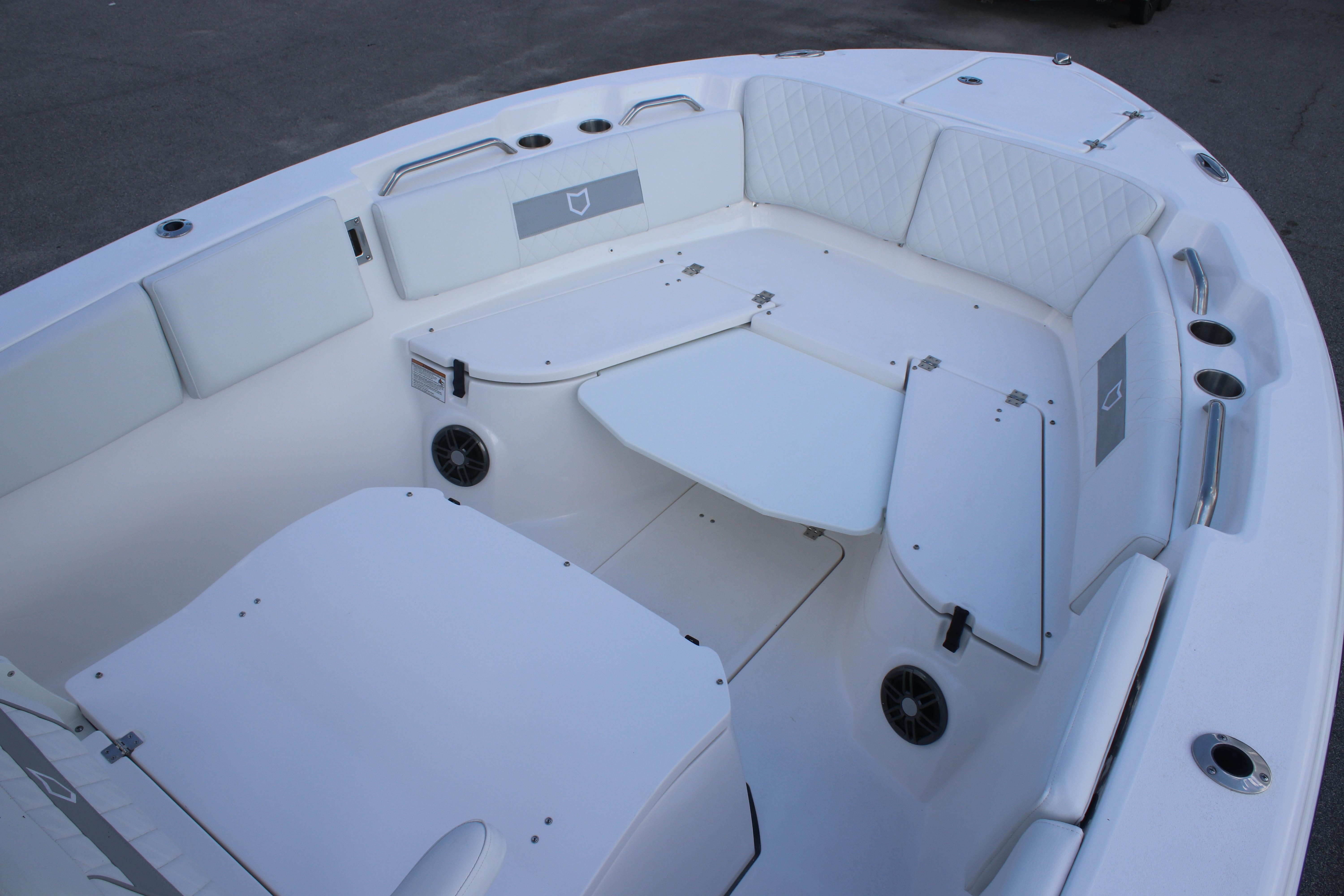 2026 Sea Fox 268 Commander boat interior with white cushioned seating and storage compartments.