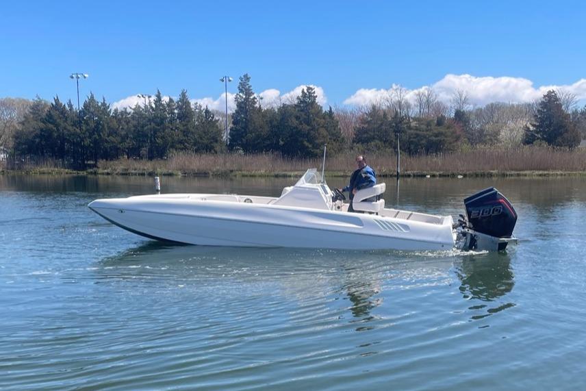 2025 Hustler 25 C3 Speedfish boat cruising on a calm lake.