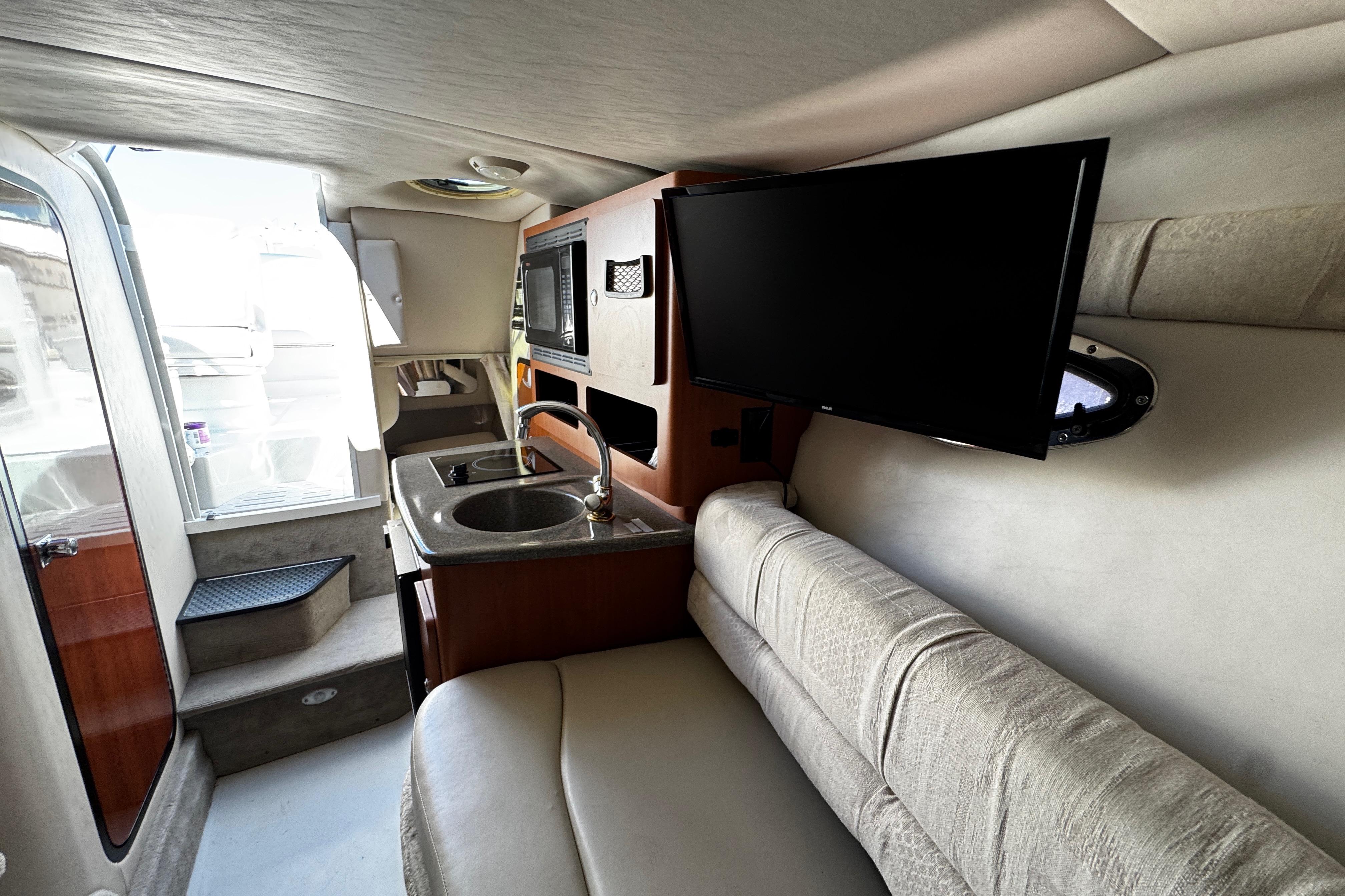Interior of 2004 Crownline 250 CR boat with kitchenette and TV.