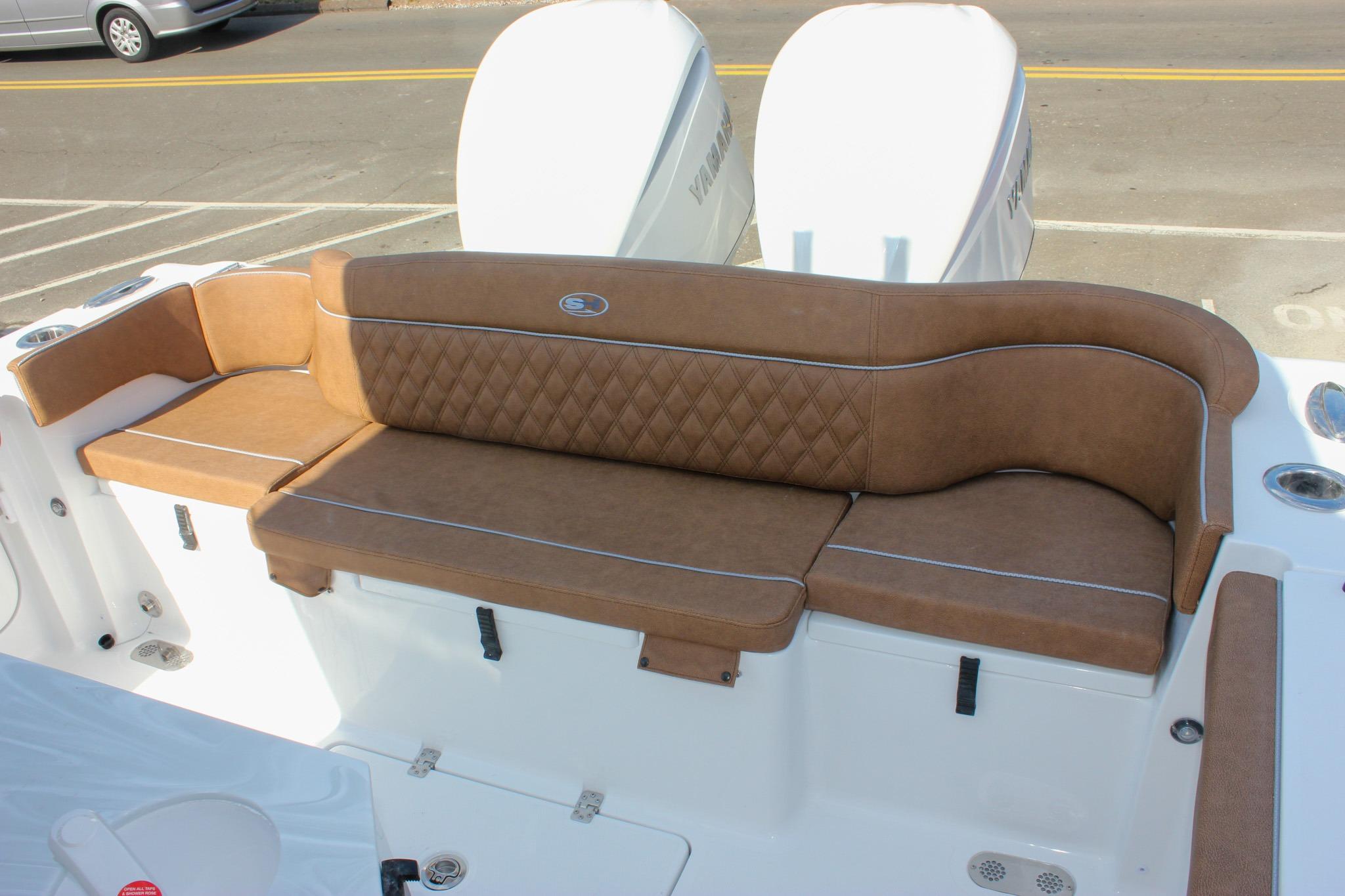 2027 Sea Hunt Ultra 275 SE boat with brown cushioned seating and dual engines.