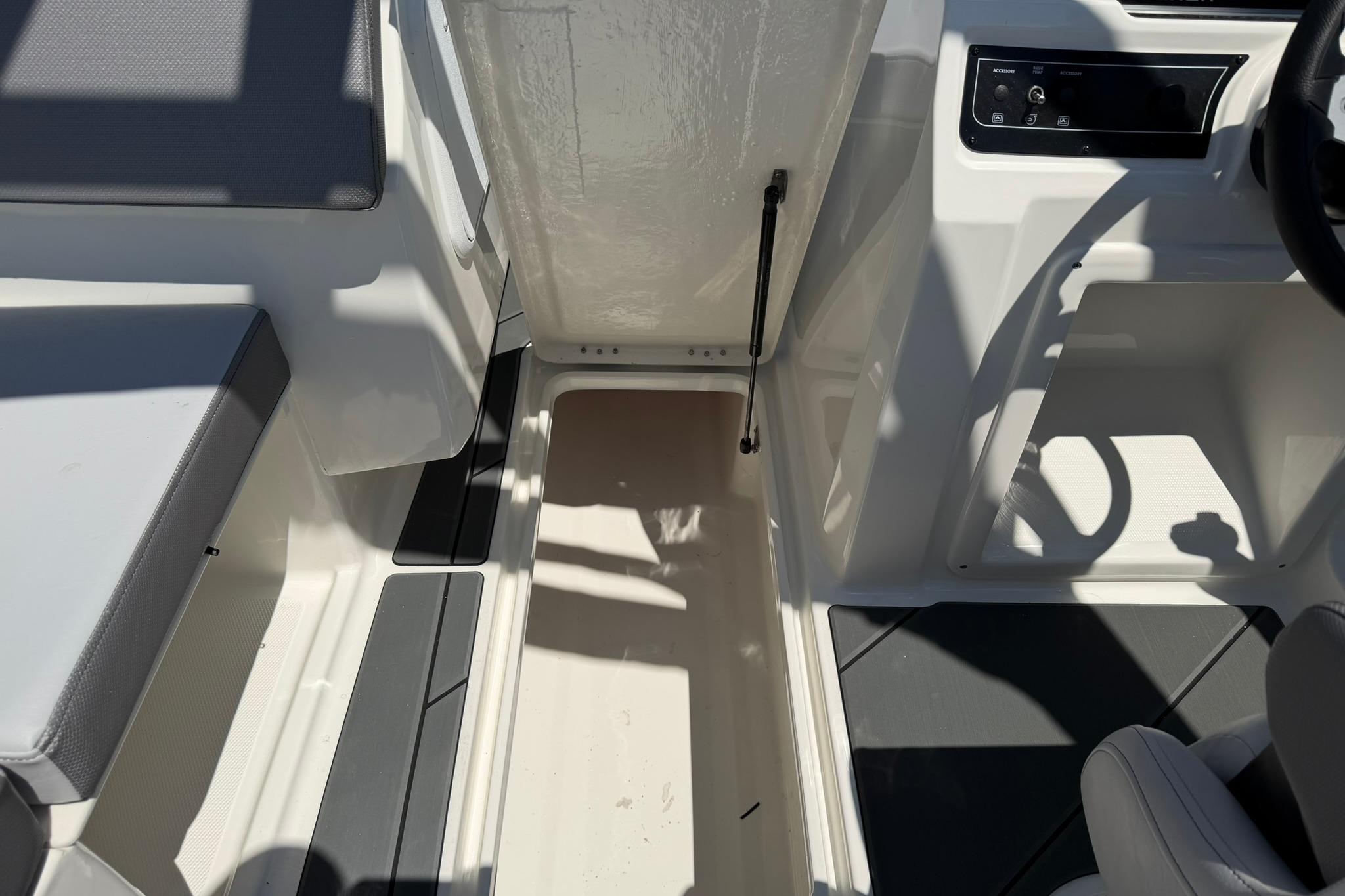 2026 Bayliner D20 boat interior with open storage compartment and seating area.