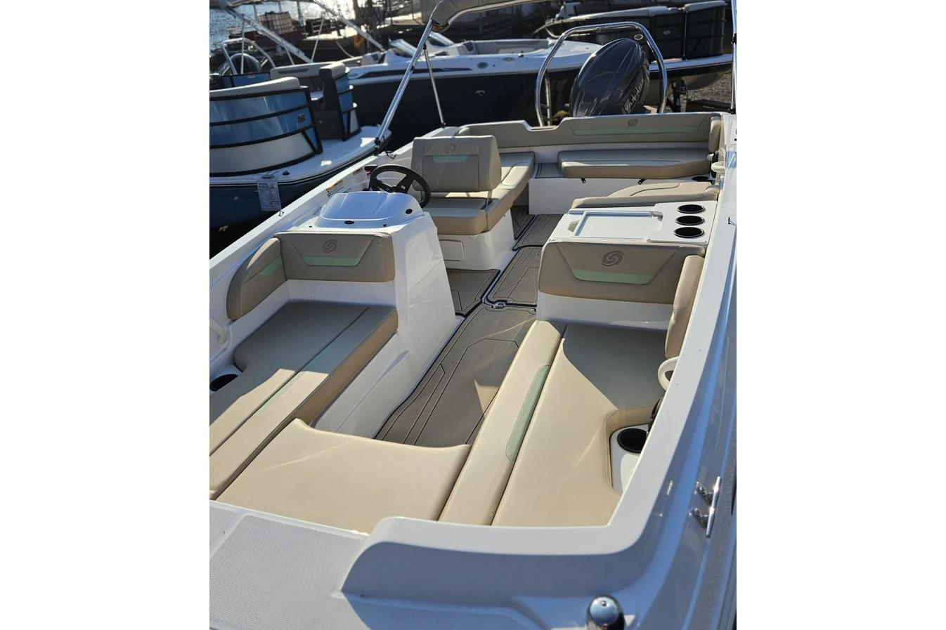 2025 Hurricane SunDeck Sport 205 OB boat interior with beige seating and steering console.