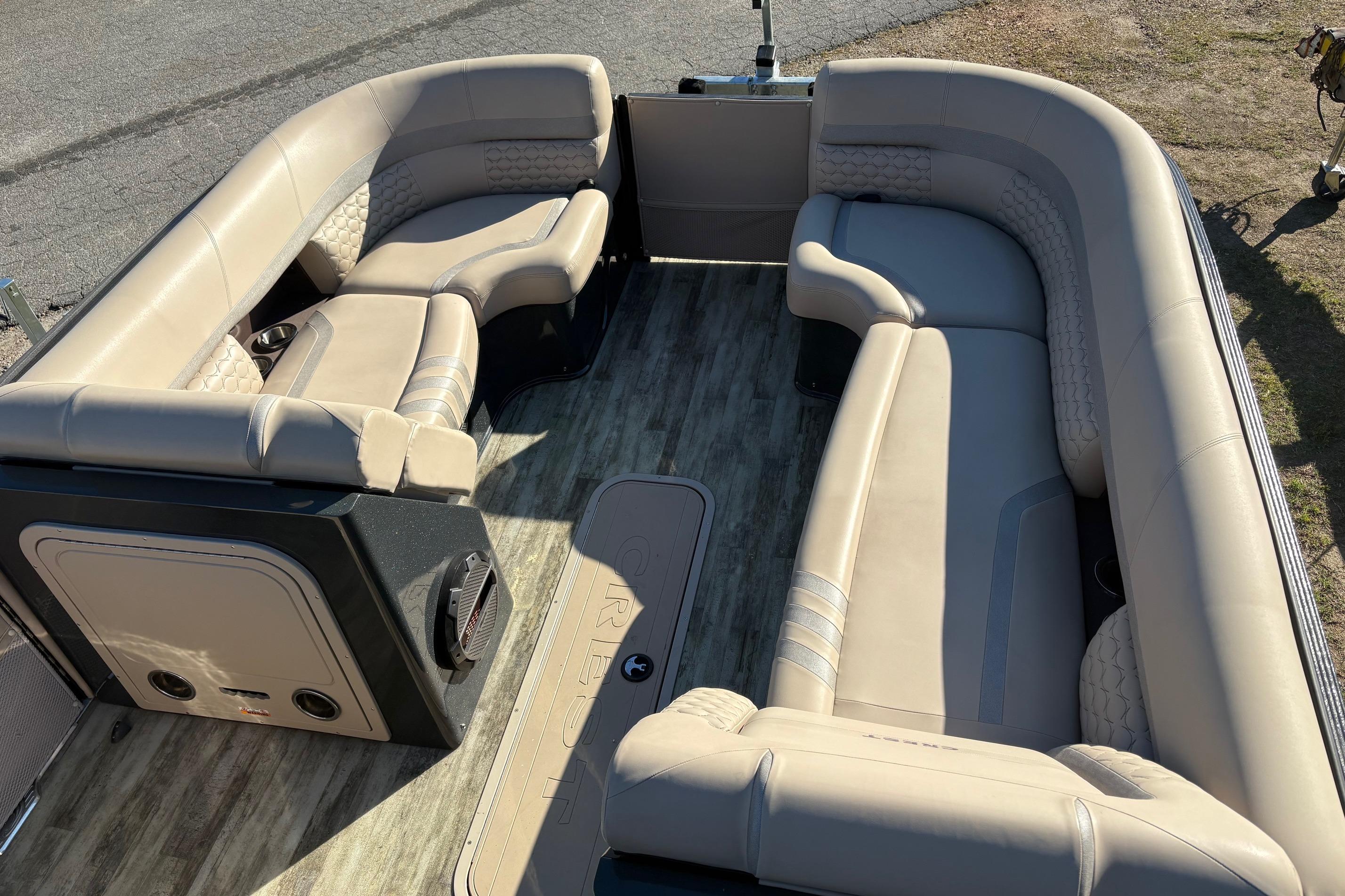 Luxurious seating on 2022 Crest Continental 250 pontoon boat, featuring beige upholstery and spacious layout.