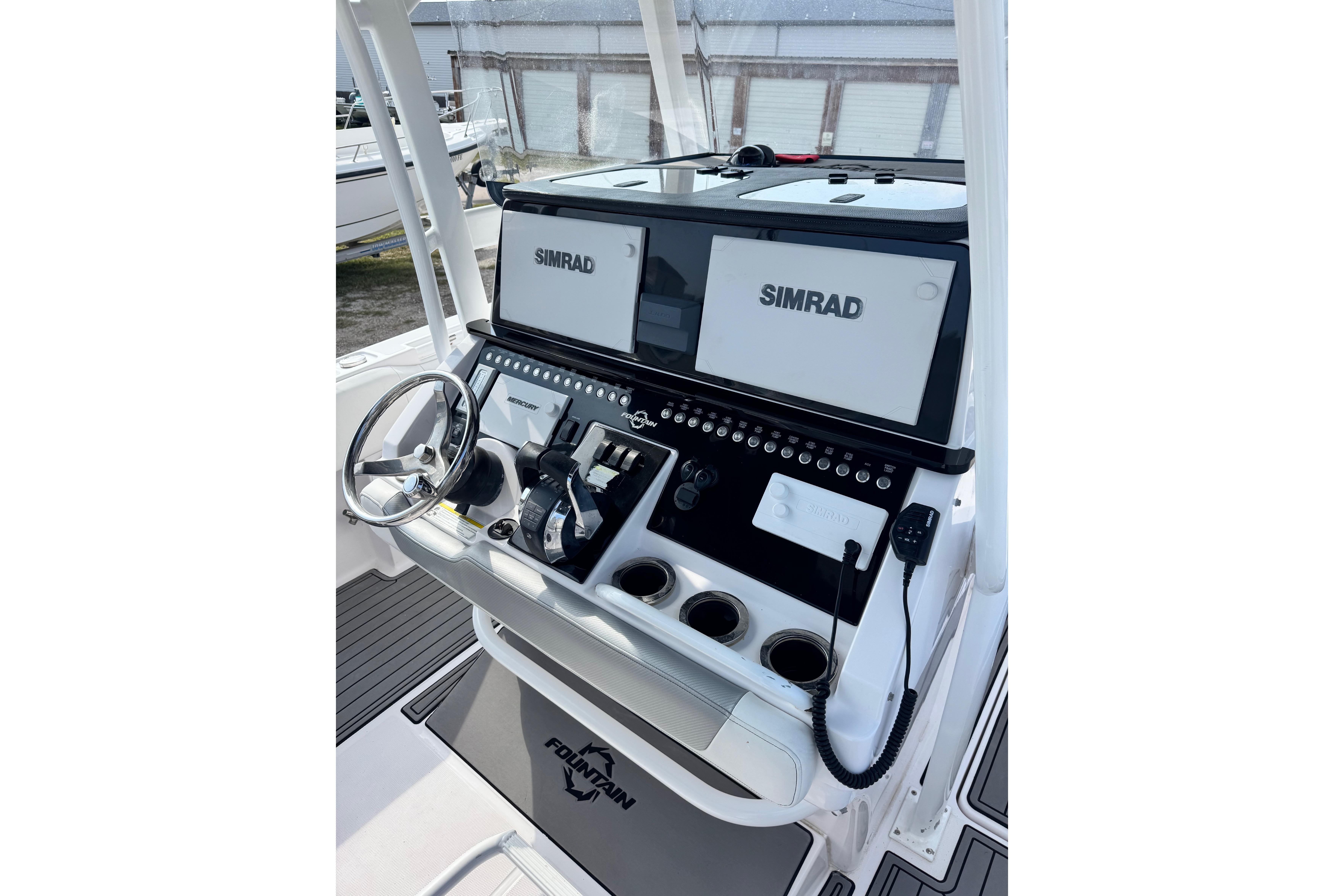 2018 Fountain 34 Center Console boat dashboard with Simrad displays and steering wheel.