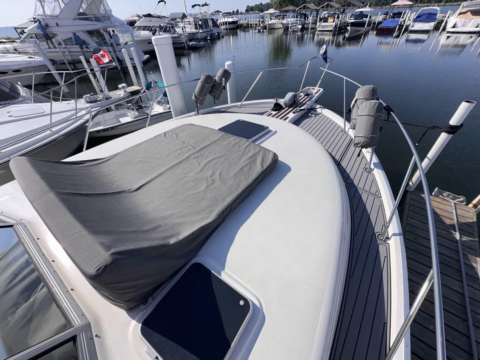 1987 Silverton 40 Double Cabin yacht docked at a marina, featuring a covered deck area.