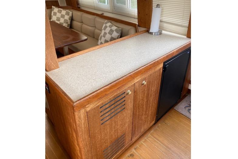 Interior of 2000 Mainship 430 Trawler with wooden cabinetry and seating area.