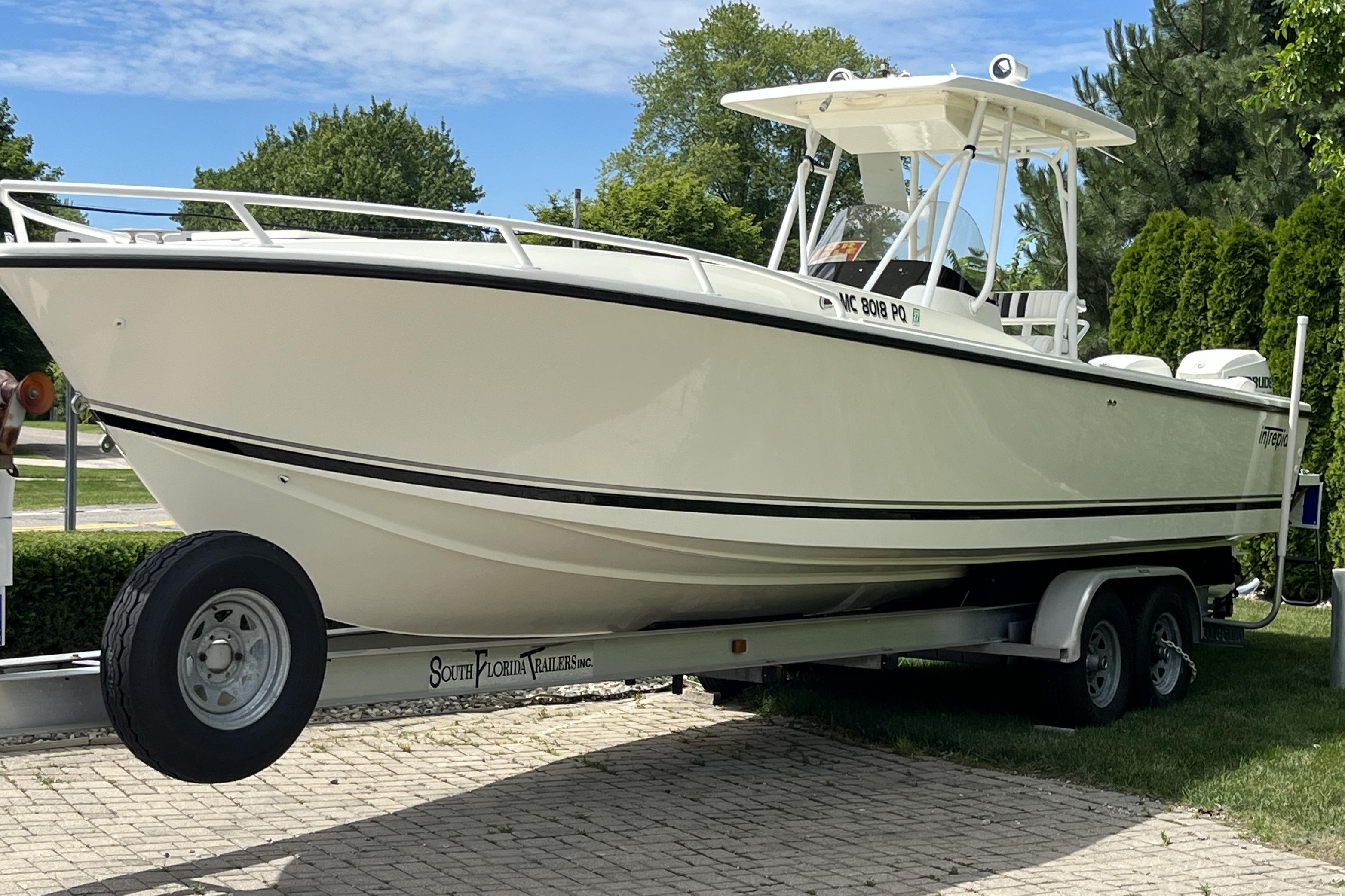 1994 Intrepid 30 Open Cuddy boat on trailer, parked outdoors.