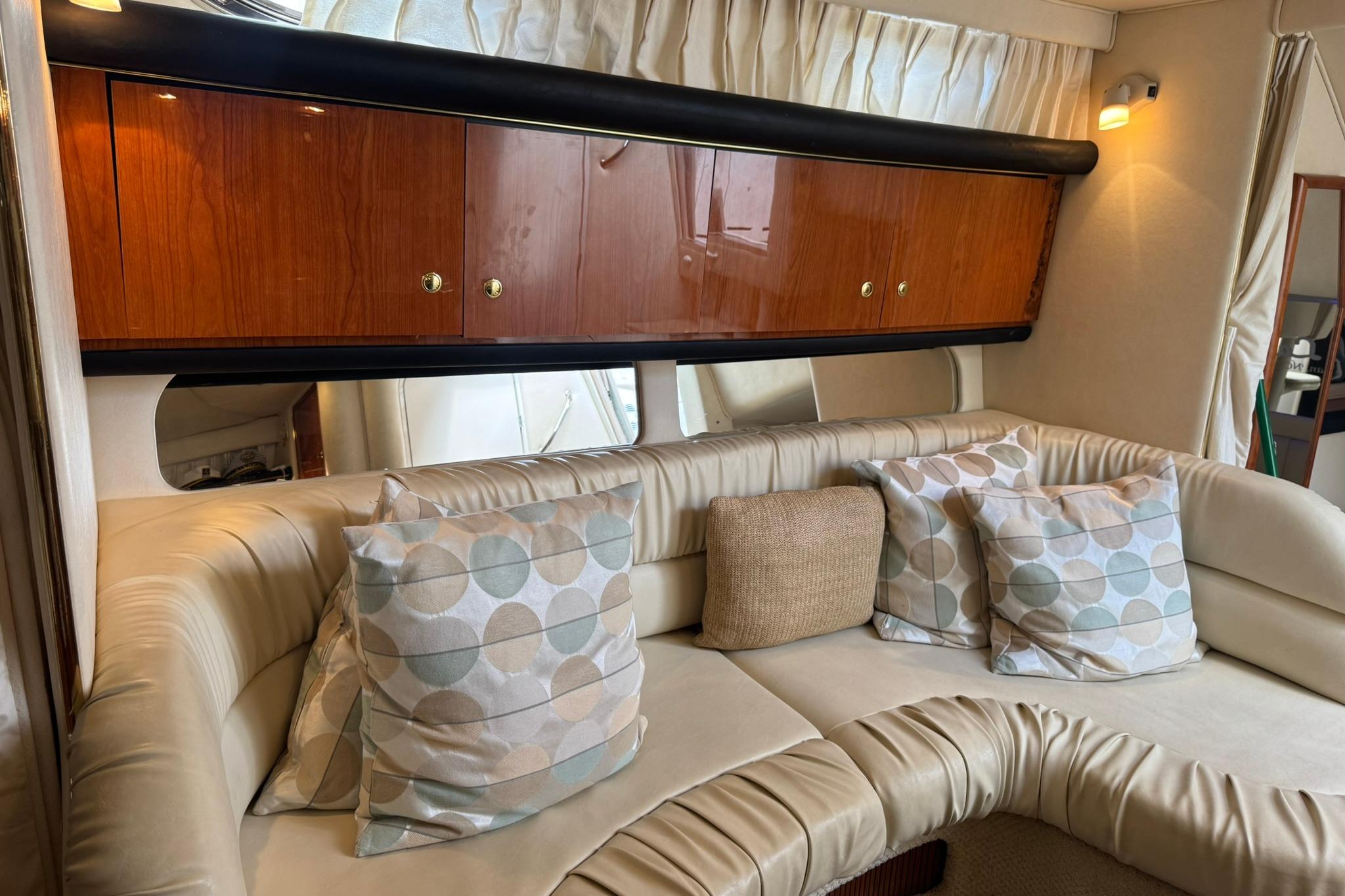 Luxurious interior of 2001 Sea Ray 340 Sundancer with plush seating and decorative pillows.