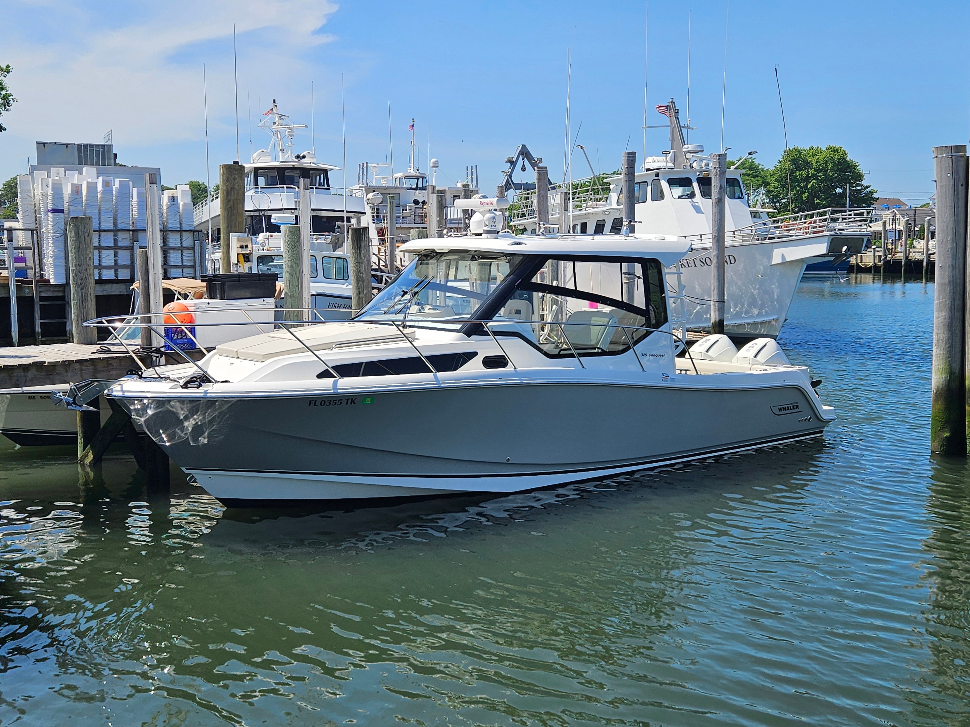 A 2023 Boston Whaler 325 Conquest is docked in the water.