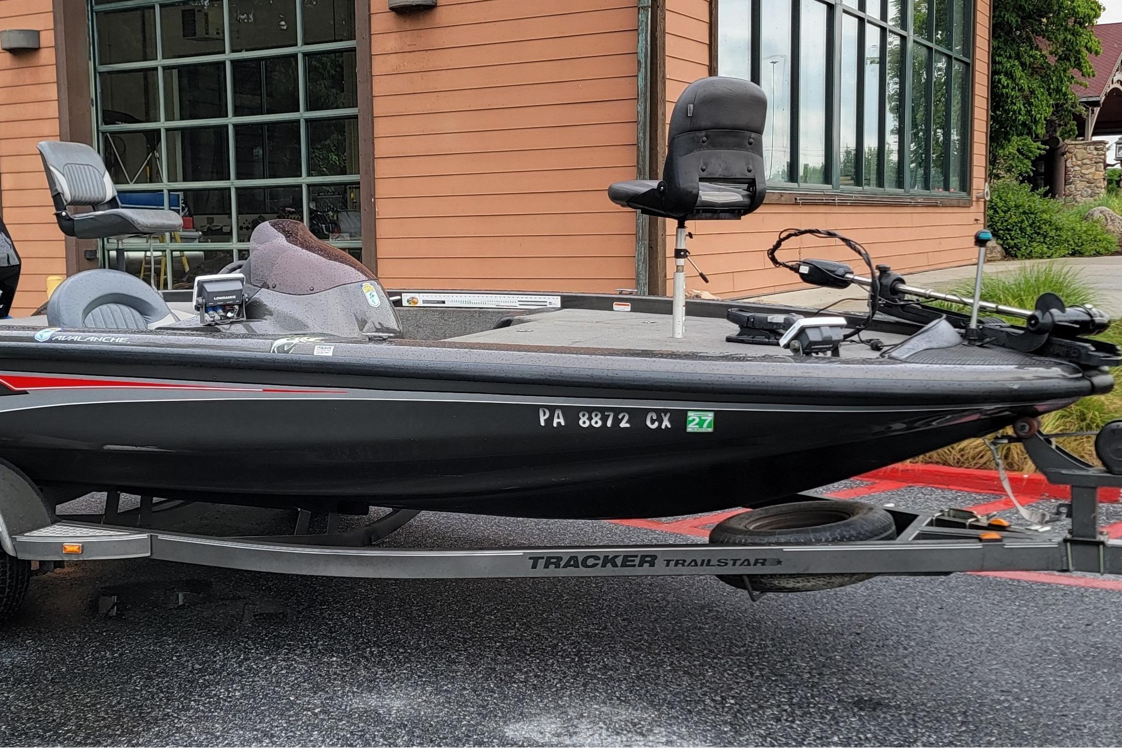 2006 Tracker Avalanche 18 SC fishing boat on trailer, parked near a building.