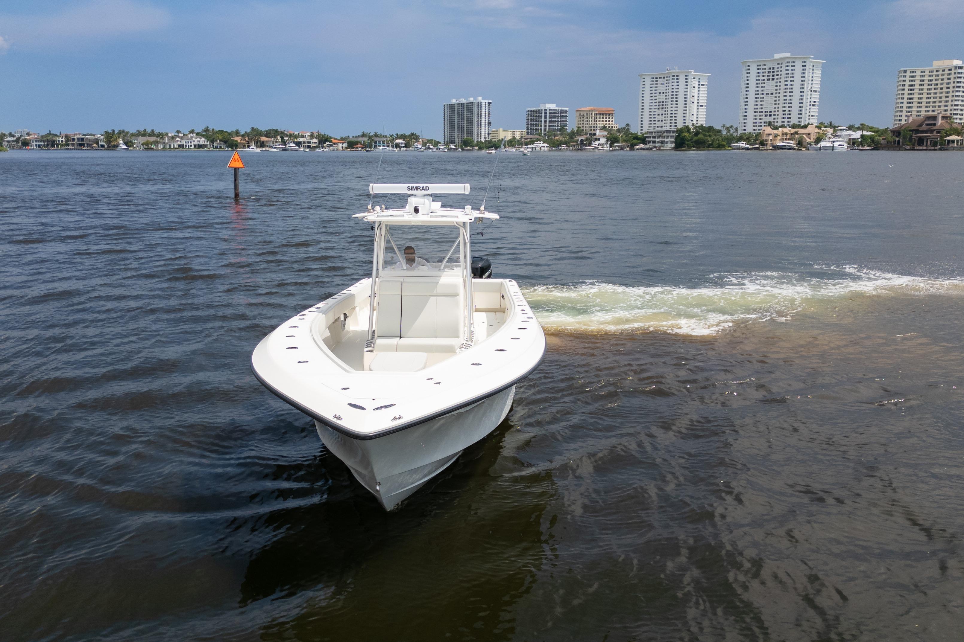 2015 SeaVee 39Z boat cruising on a calm waterway with city skyline in background.