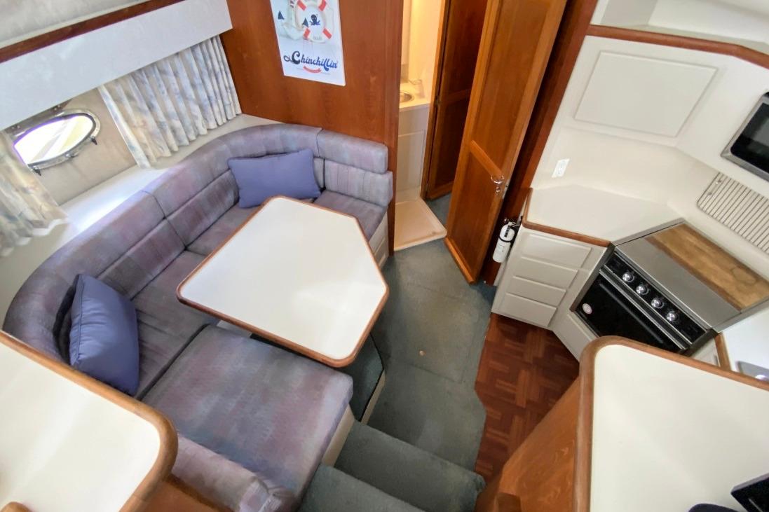 Interior of 1992 Carver 36 Aft Cabin with cozy seating and compact kitchen.