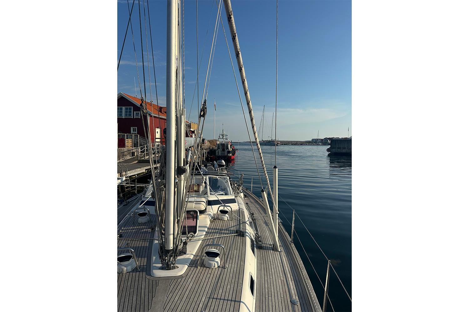 Sailboat Najad 460, 2004 model, docked at a serene marina under clear skies.