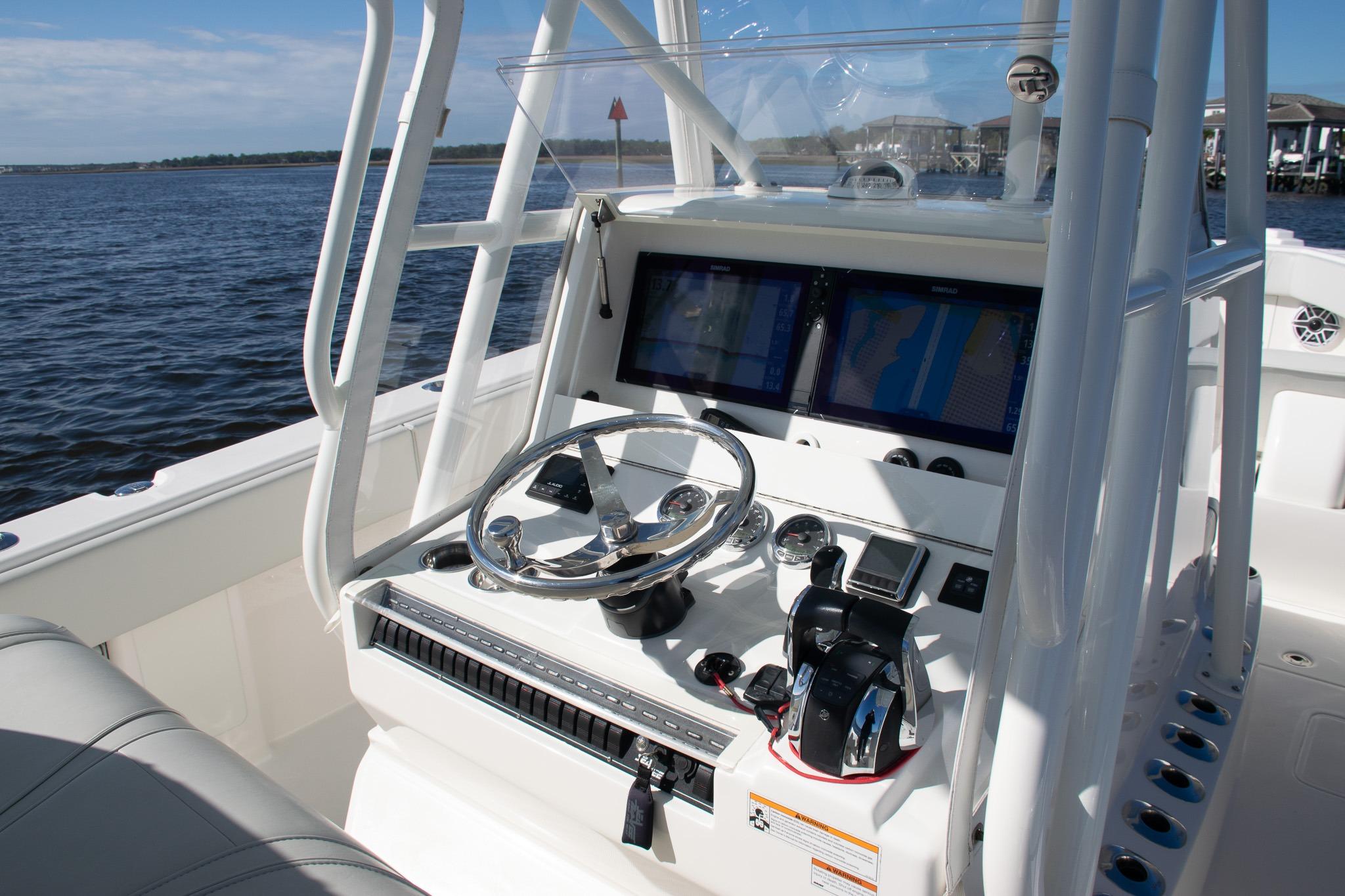 2022 SeaVee 322Z boat helm with dual screens and steering wheel on open water.
