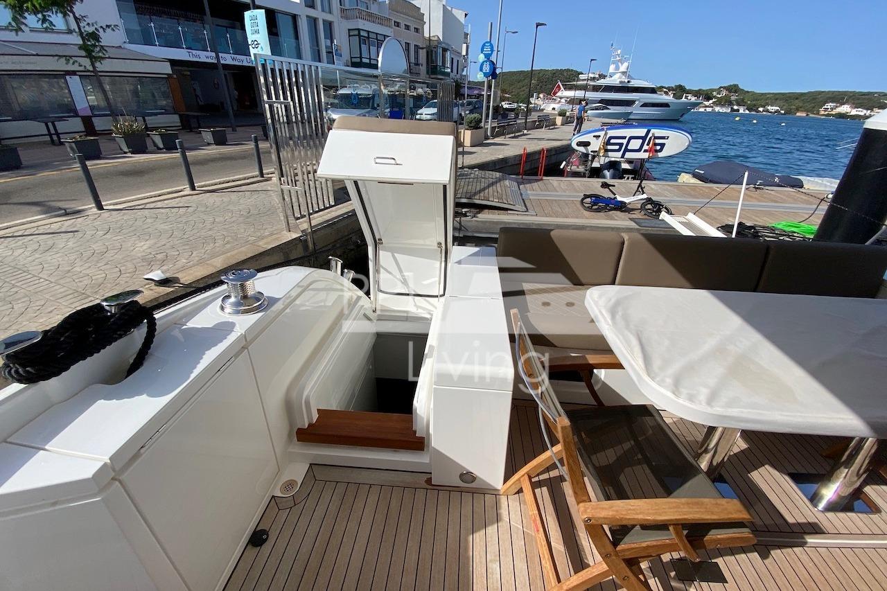 Luxury yacht Fairline Squadron 65, 2018 model, docked with elegant outdoor seating area.