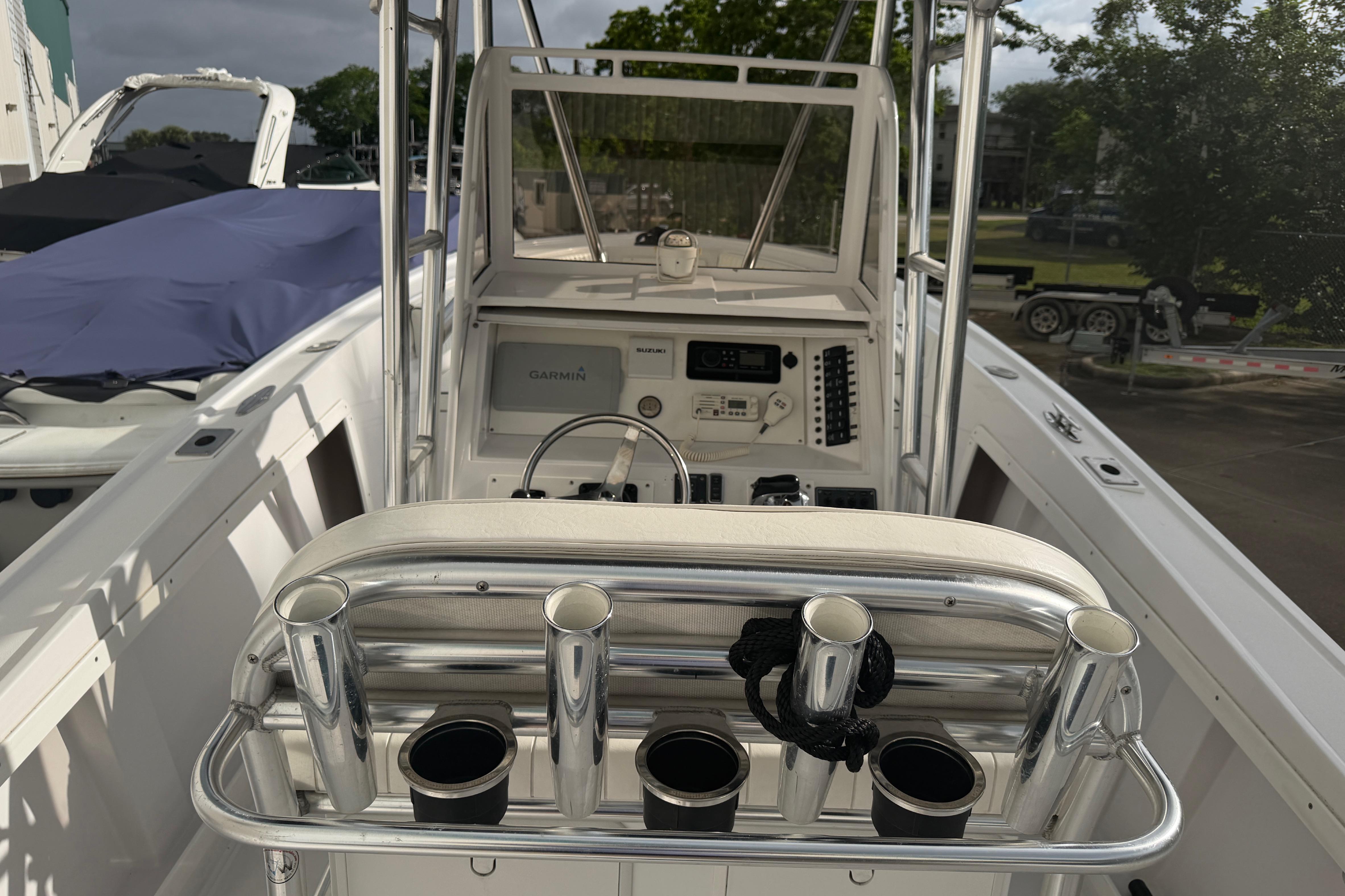 1990 Mako 241 Center Console boat interior with steering and rod holders.