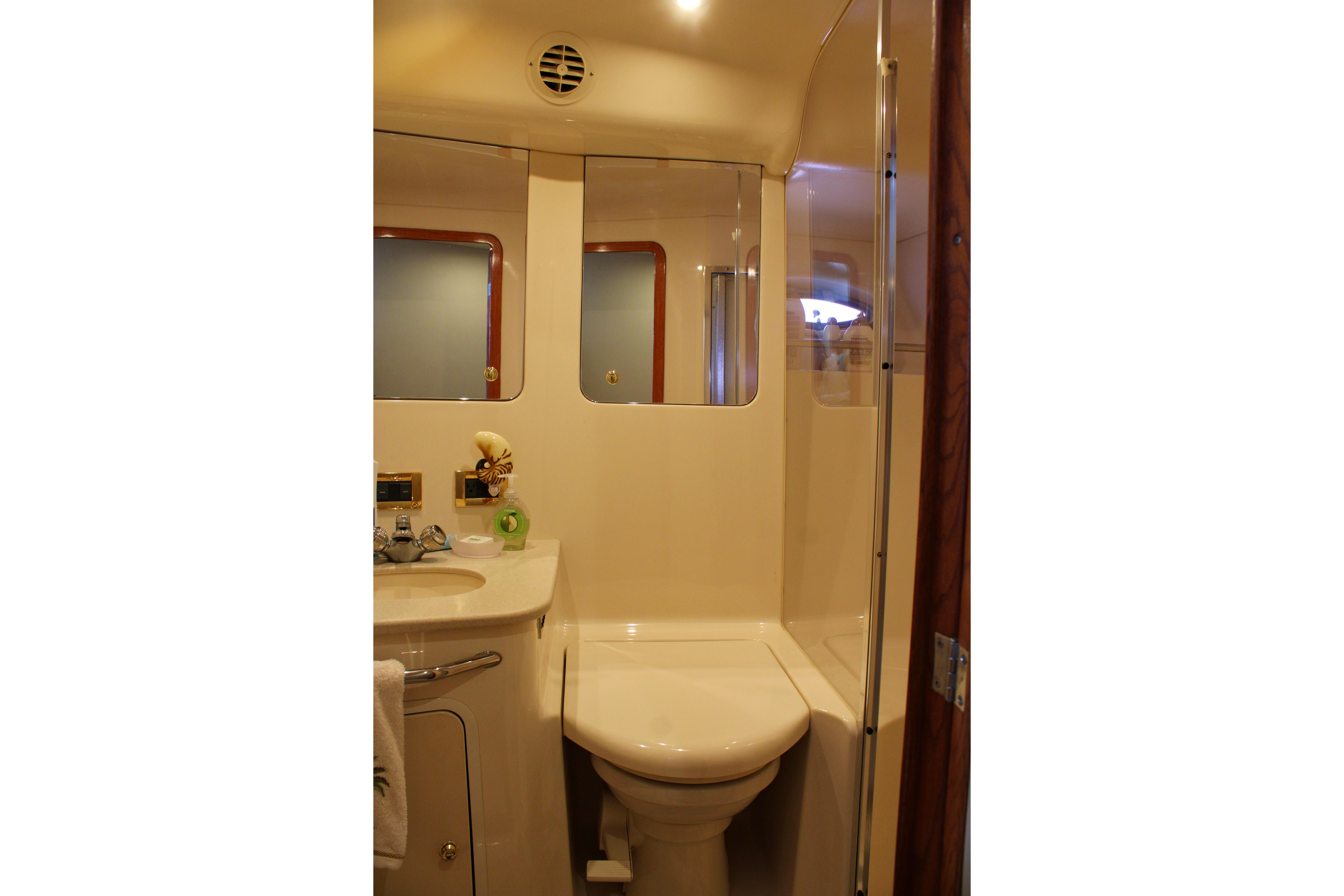 Bathroom interior of 1999 Sea Ray 480 Sedan Bridge yacht, featuring sink and shower.