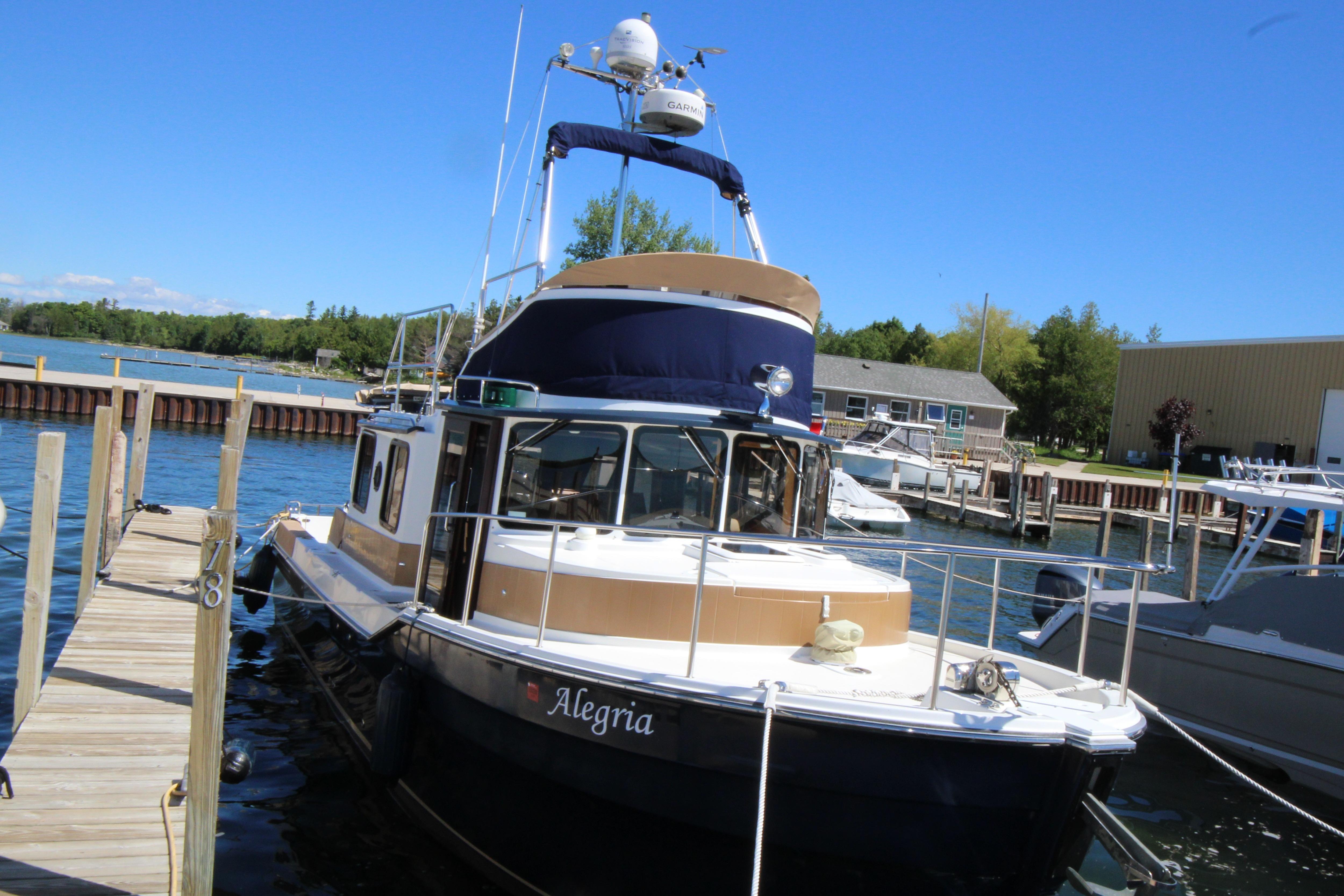 2013 Ranger Tugs R-31 CB docked at marina under clear blue sky.