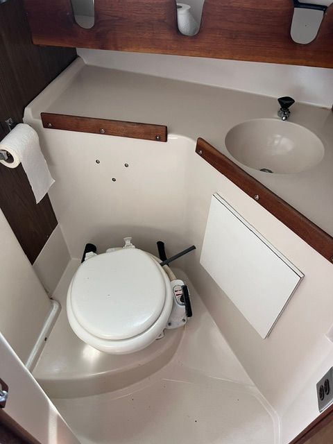 The image shows a boat bathroom with a toilet and a sink.