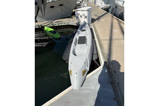 A 1982 Lancer 45 Motorsailer docked, with a small green kayak nearby.