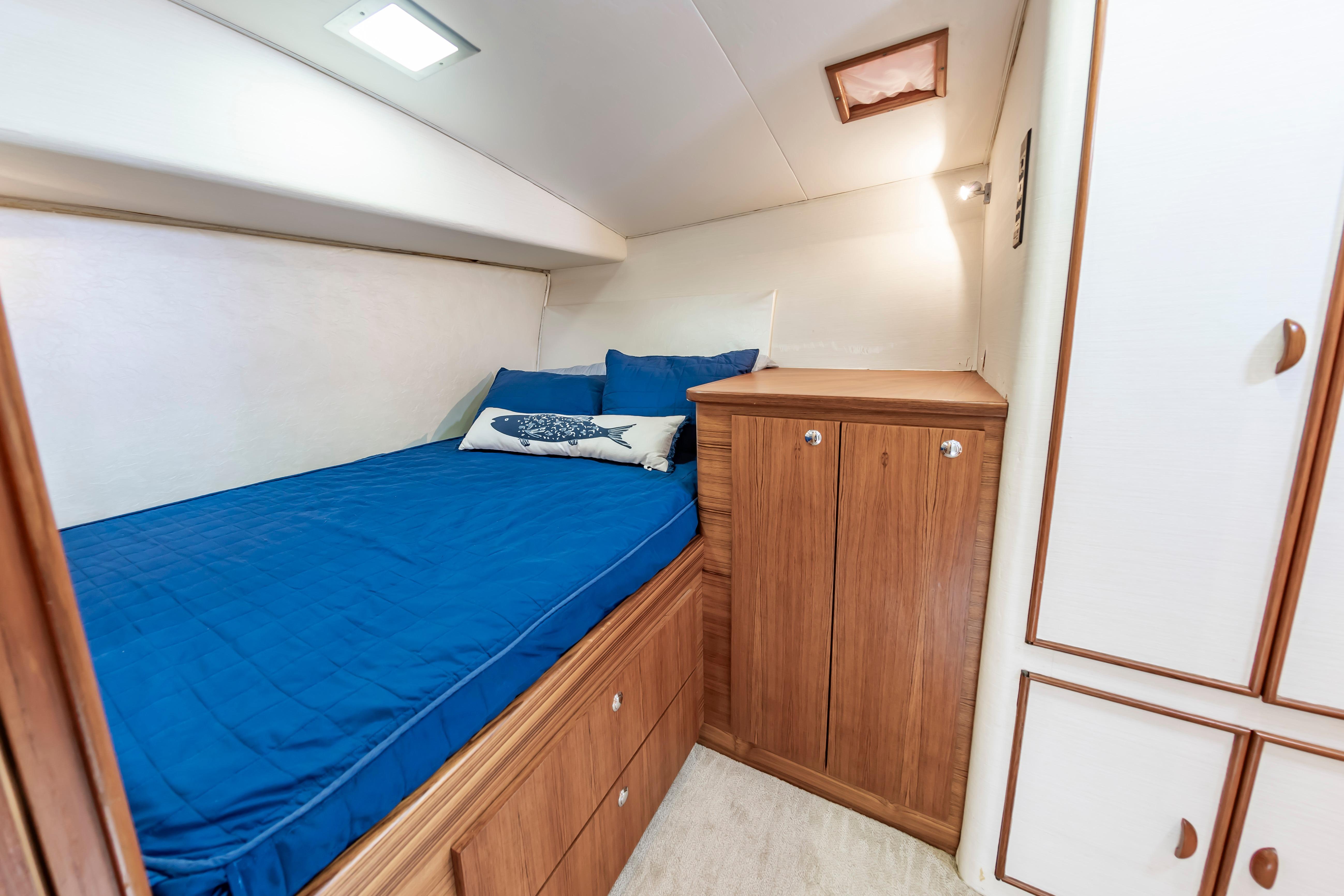 Cozy cabin interior of 1993 Custom Carolina Scarborough 56 Convertible with blue bedding.