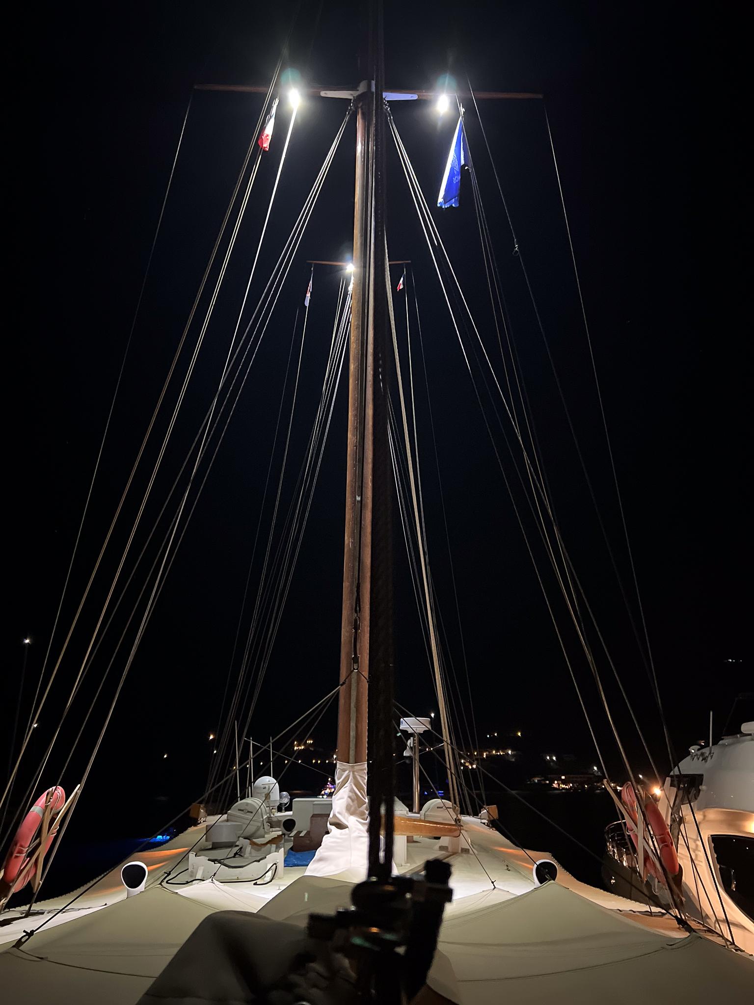 Sailboat deck at night, Psarros Shipyard 1969, illuminated mast and rigging.