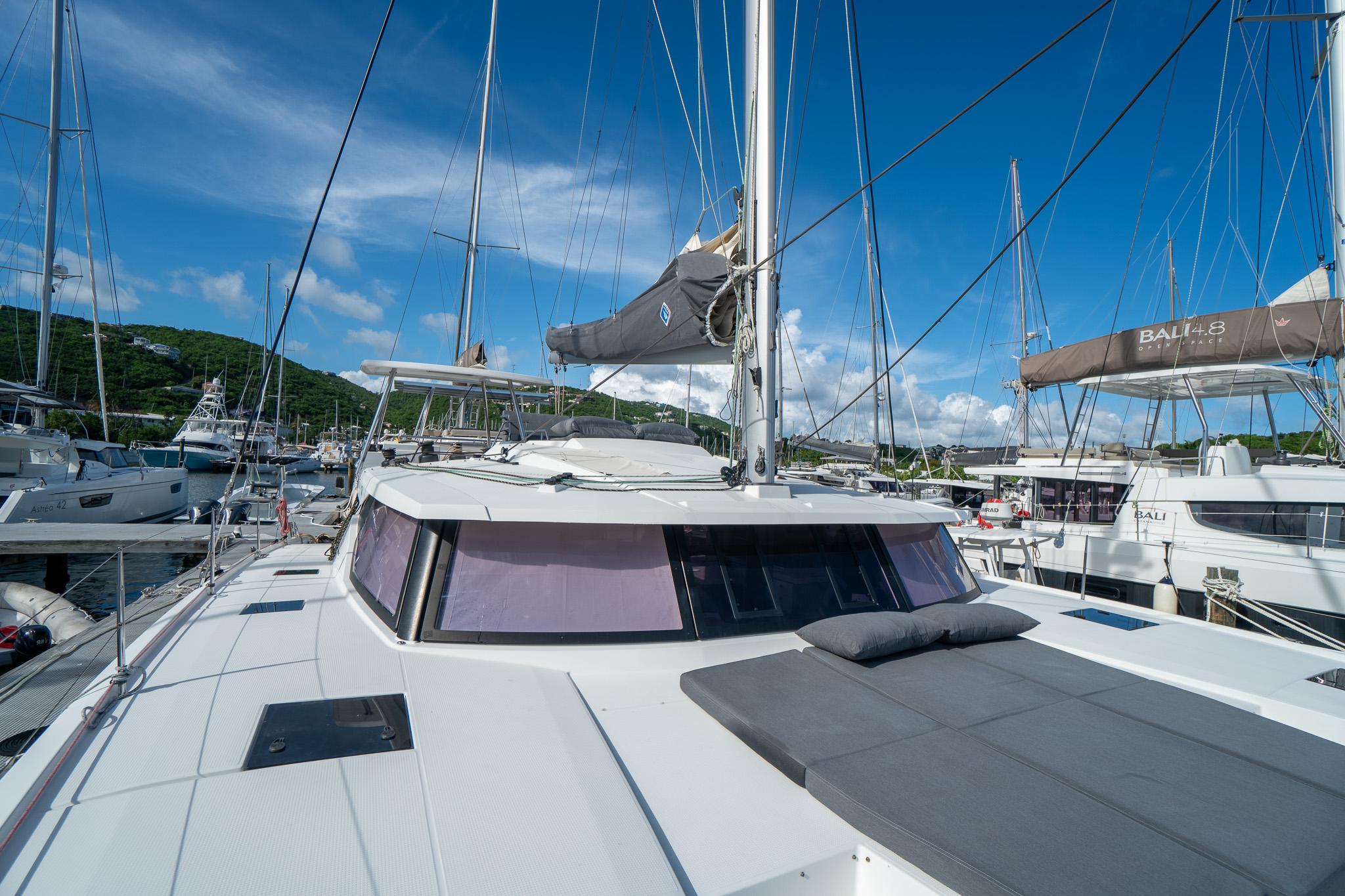 Fountaine Pajot Saona 47 catamaran, 2020 model, docked in a marina under clear blue skies.
