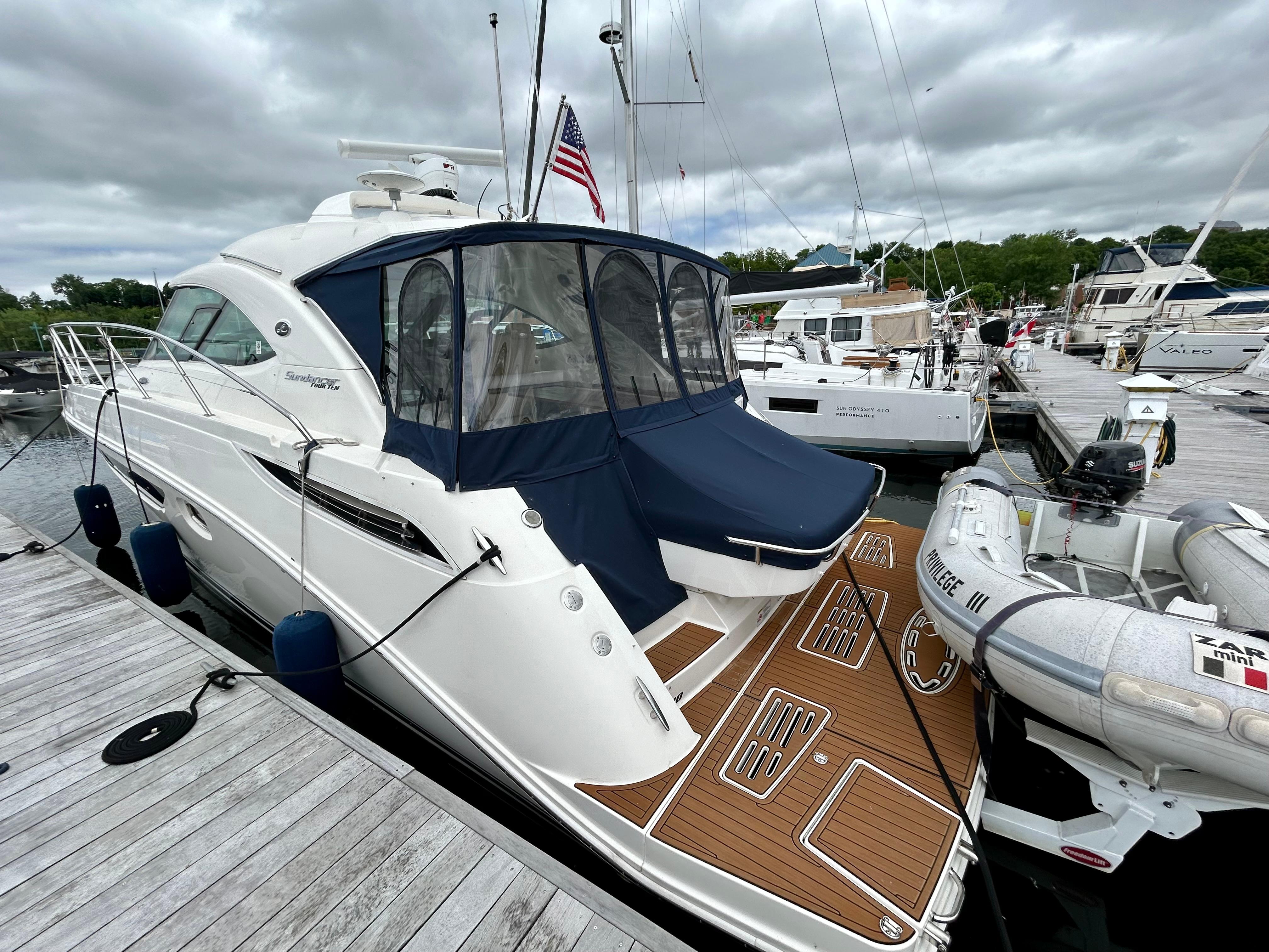 2015 Sea Ray 410 Sundancer yacht docked at marina with American flag.