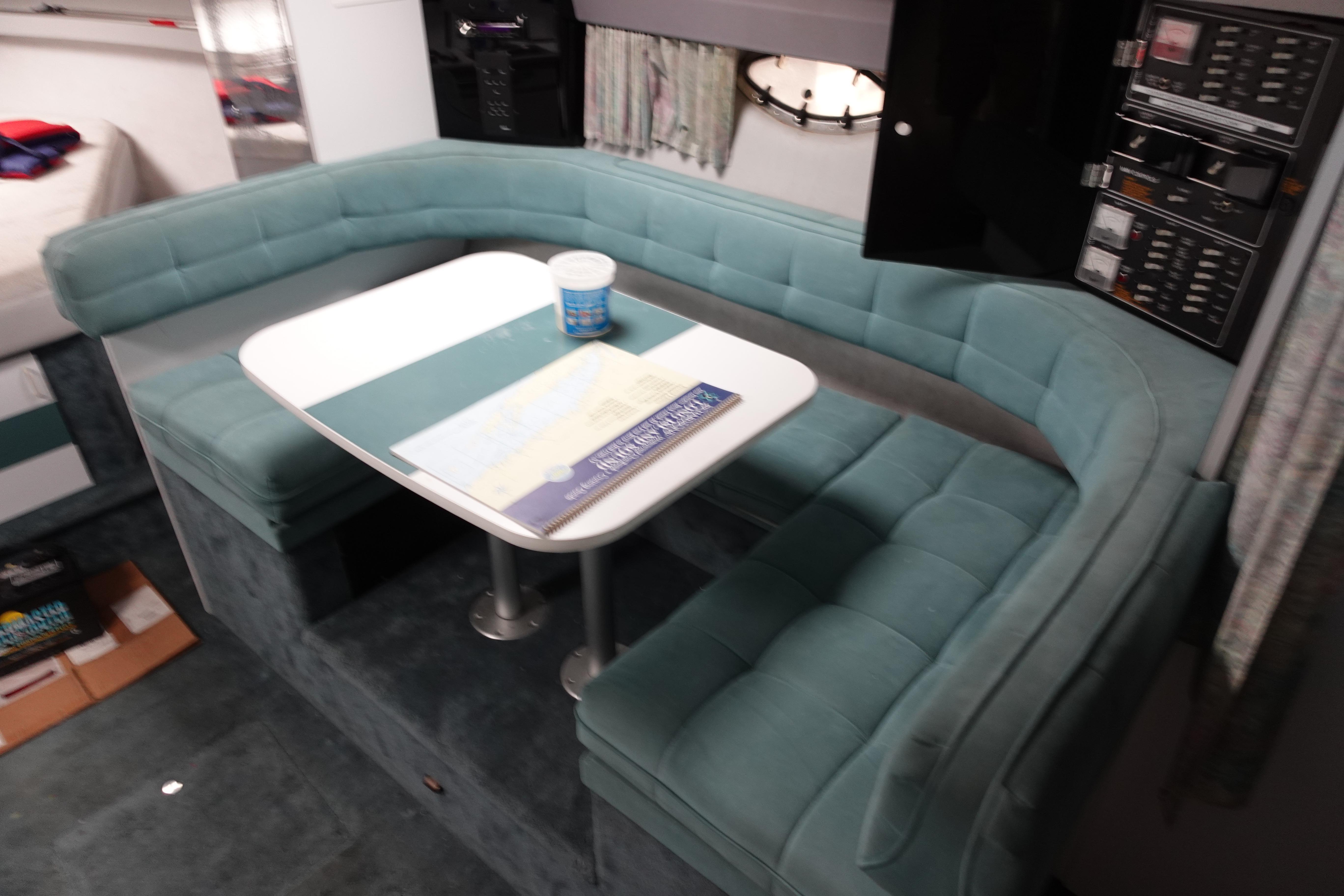 Interior of 1993 Formula 34 Performance Cruiser with teal seating and dining table.