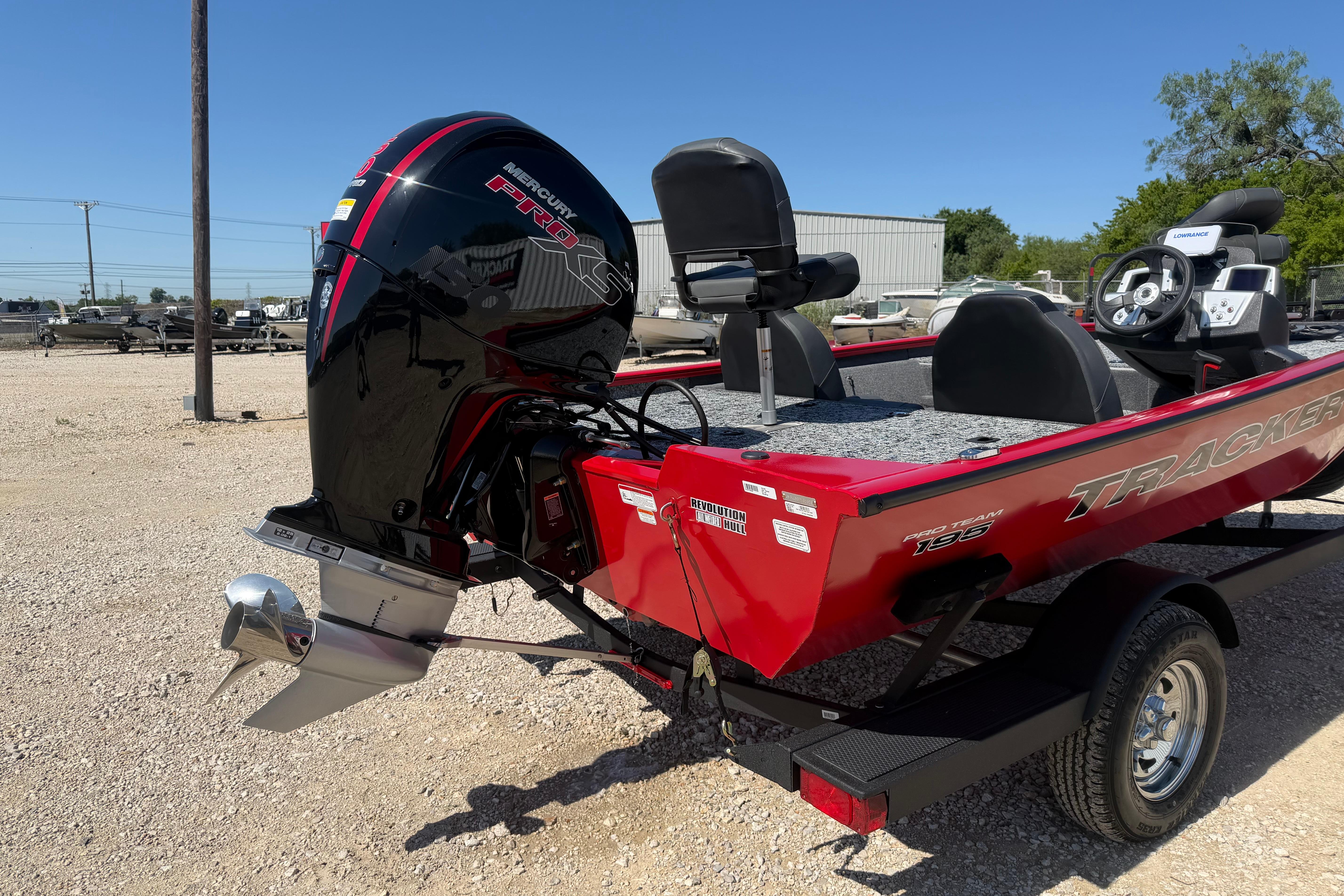Red 2026 Tracker Pro Team 195 boat with Mercury Pro XS engine, parked outdoors.