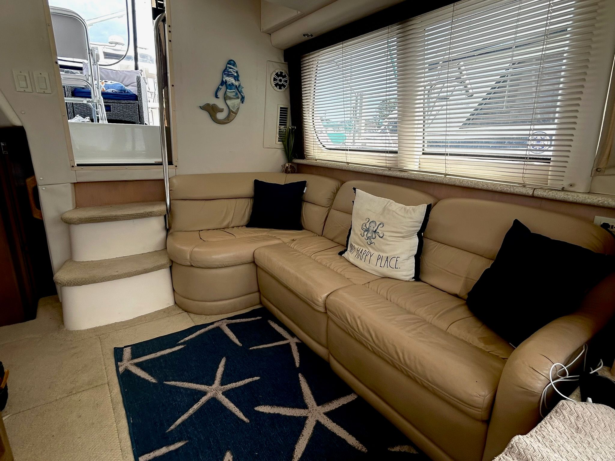 Interior of Carver 356 yacht with beige sofa and nautical decor.