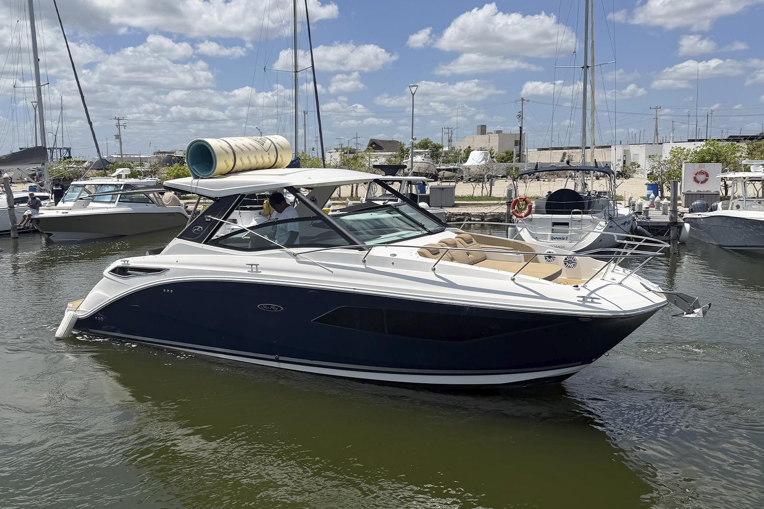 2019 Sea Ray Sundancer 320 yacht docked in a marina under a partly cloudy sky.
