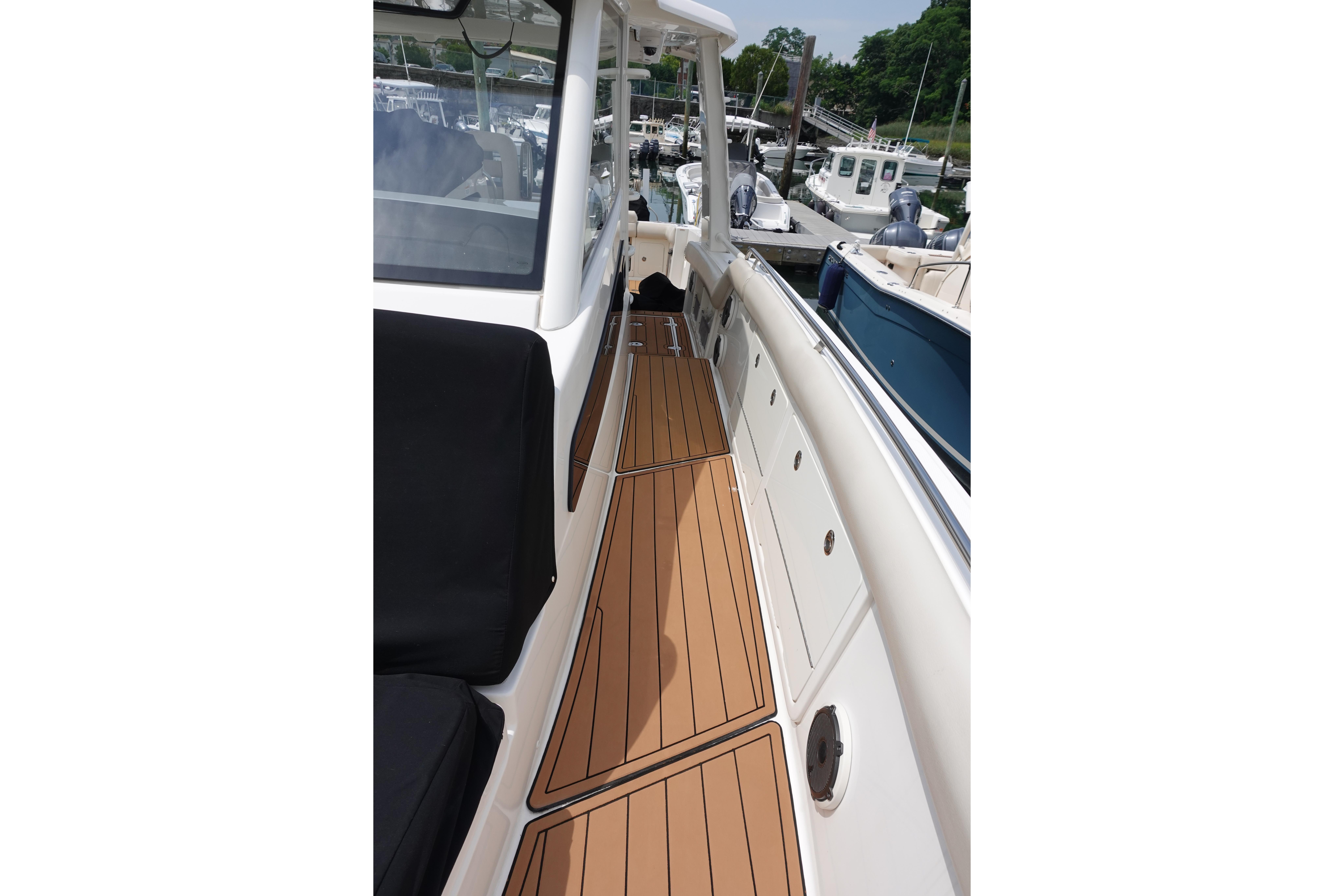 Boston Whaler 420 Outrage 2020 boat deck with teak flooring at marina.