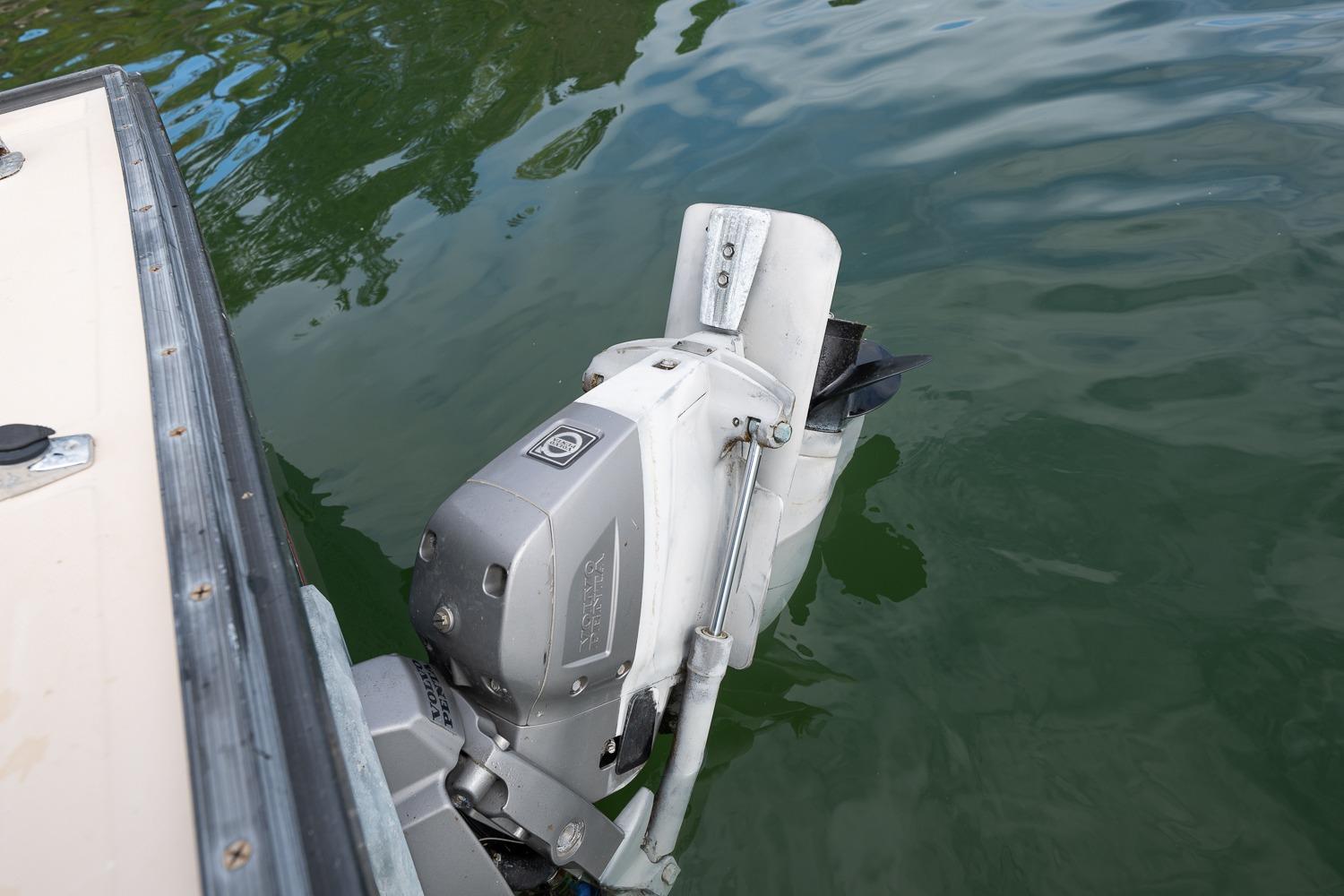 Outboard motor on 1989 Ellis 24 Open boat in calm water.