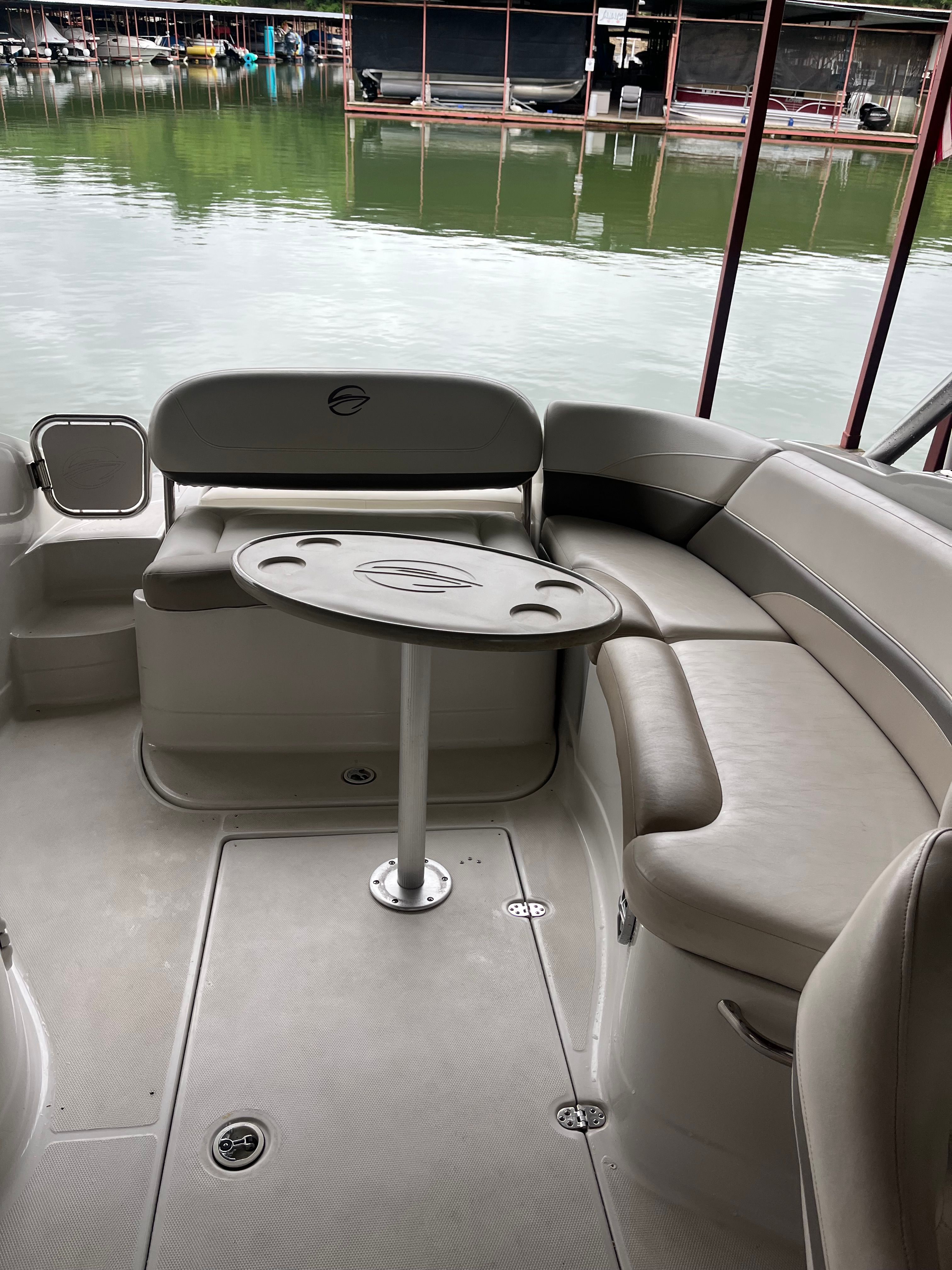 The image shows the cockpit of a 2008 Crownline 252EX boat with gray seating and a table.