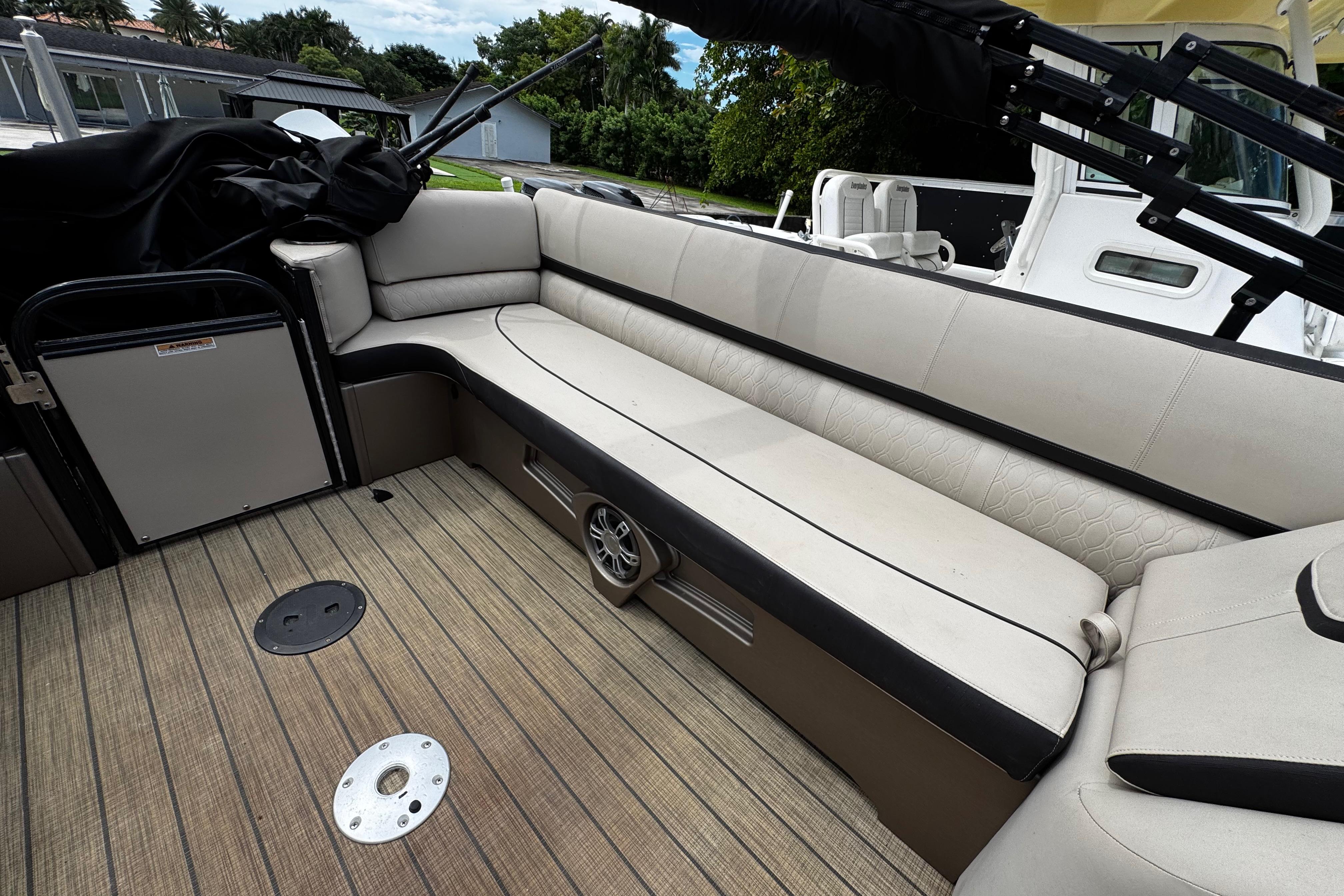 2023 Tahoe Pontoon Cascade Platinum Quad Lounger interior with beige seating and wood flooring.