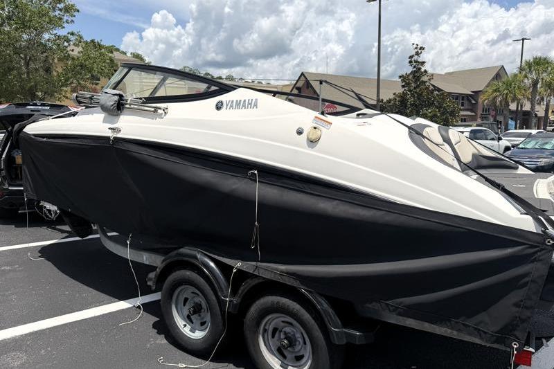 2017 Yamaha Boats SX210 on trailer in parking lot under cloudy sky.
