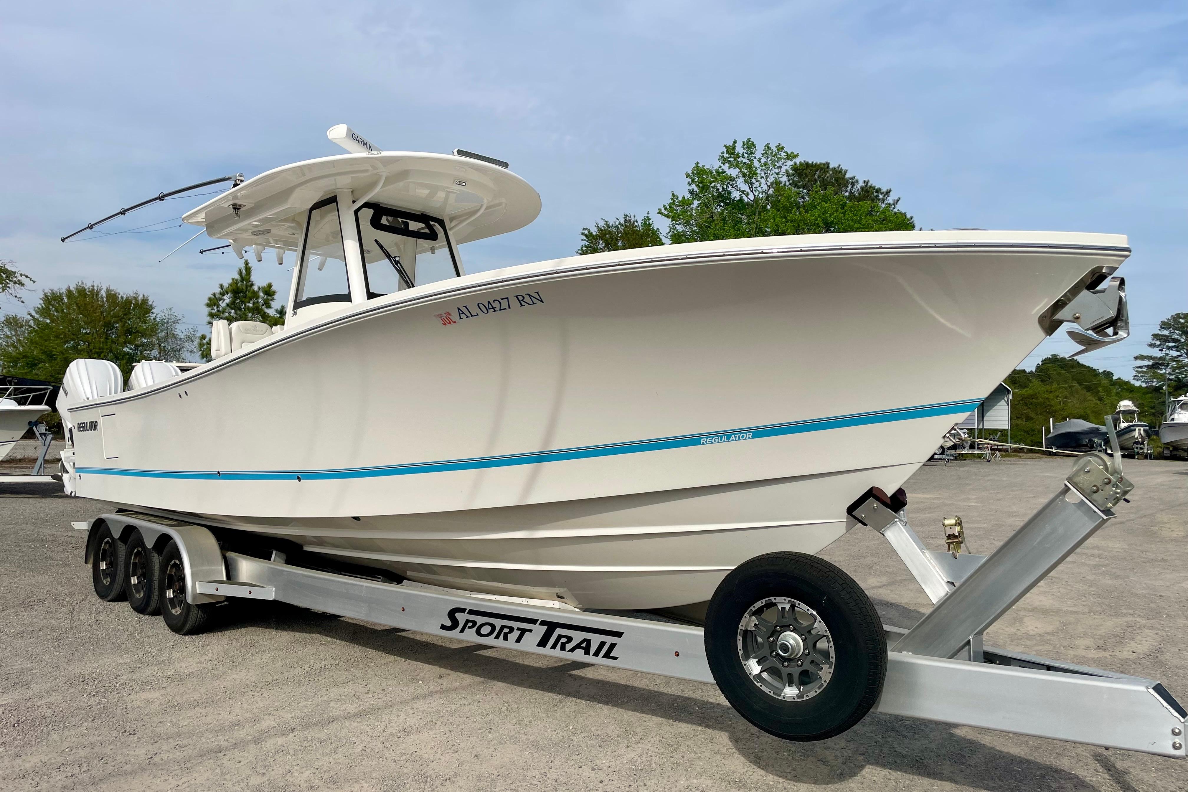 2023 Regulator 34 boat on Sport Trail trailer, parked outdoors.