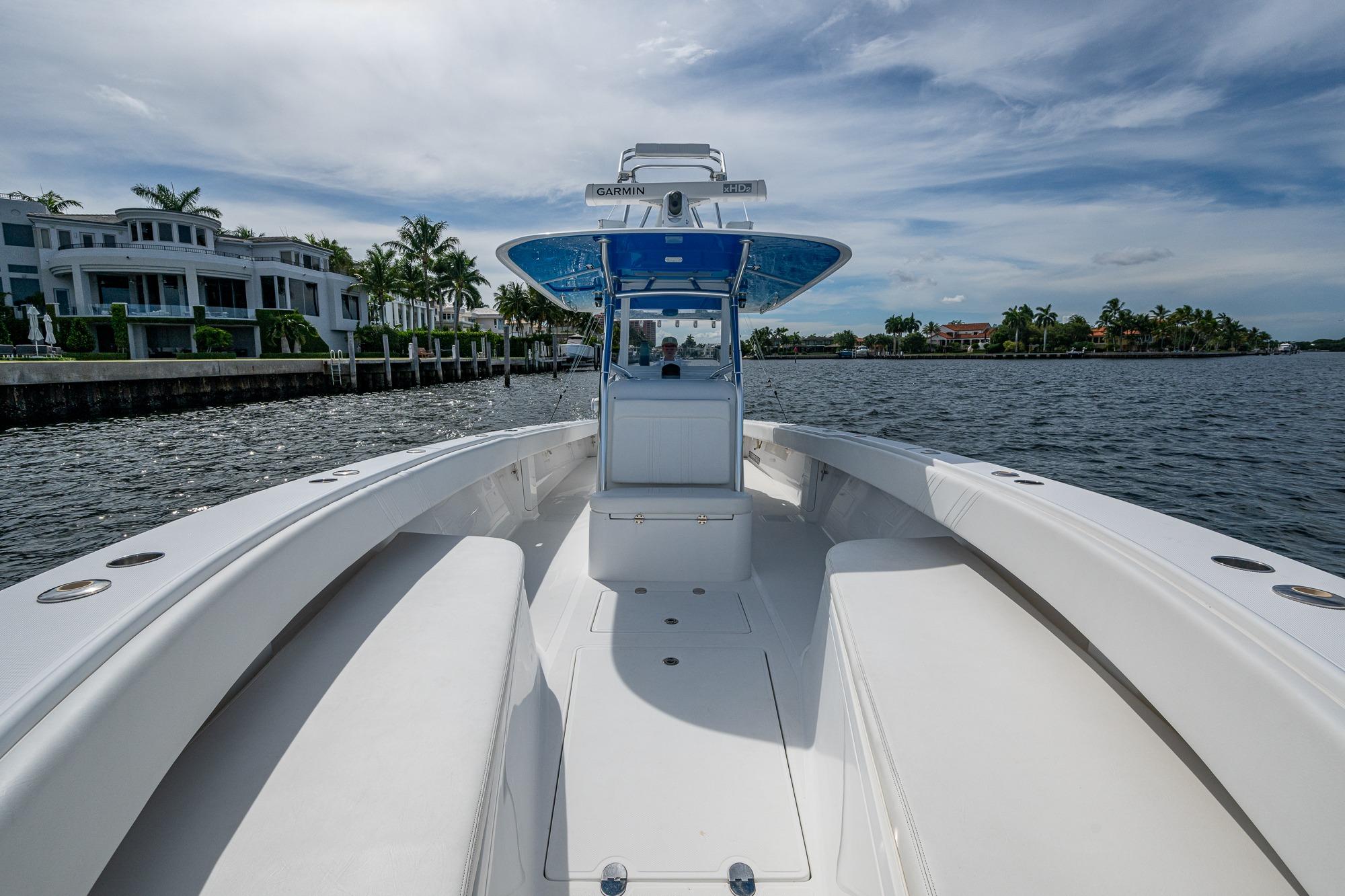 2015 Bahama 41 boat cruising on a scenic waterway with luxury homes in the background.