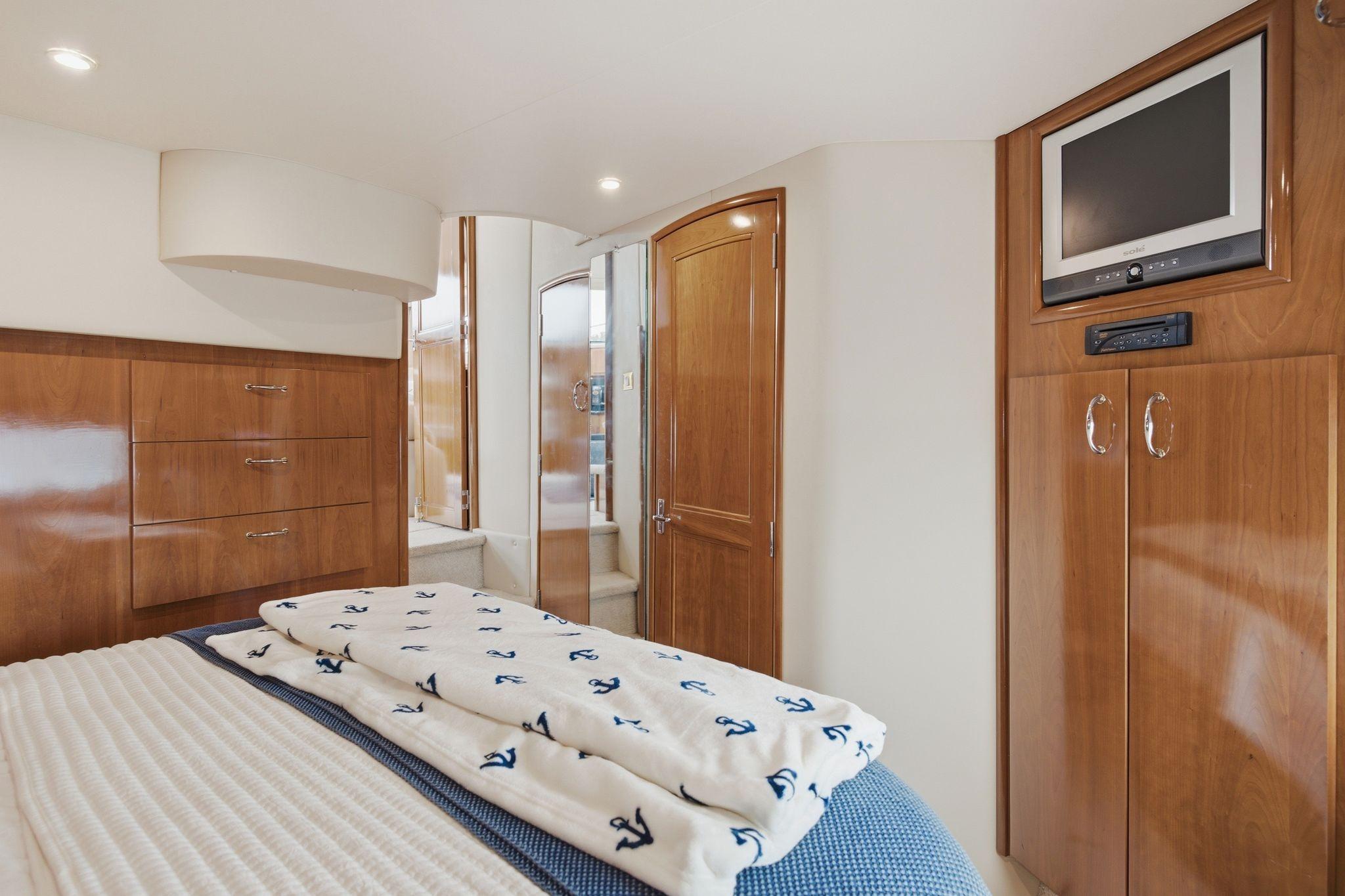 Luxurious cabin interior of 2005 Carver 39 Motor Yacht with wood finishes and TV.