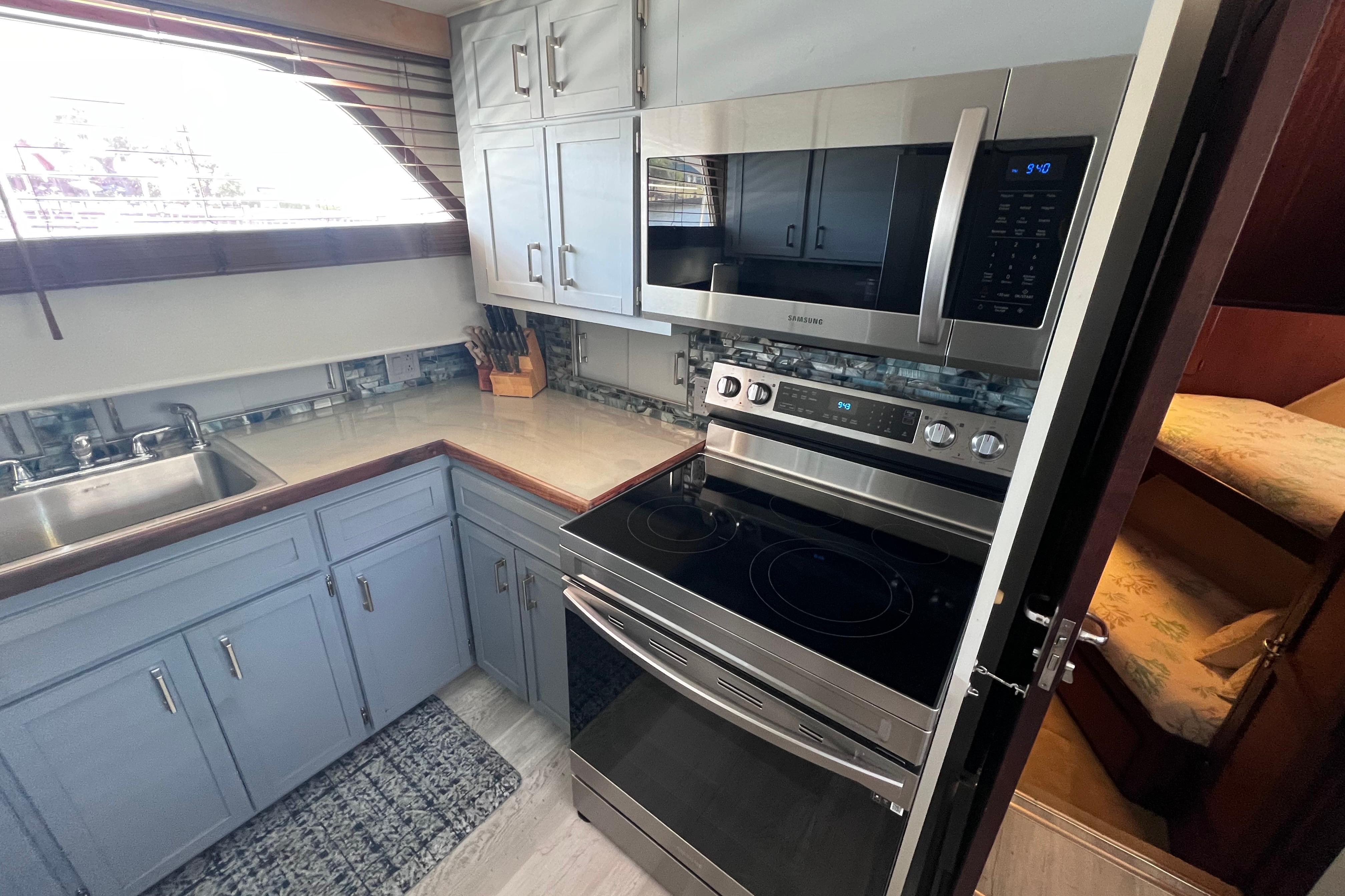 Modern kitchen in 1987 Hatteras 70 Cockpit Motor Yacht with stainless steel appliances.