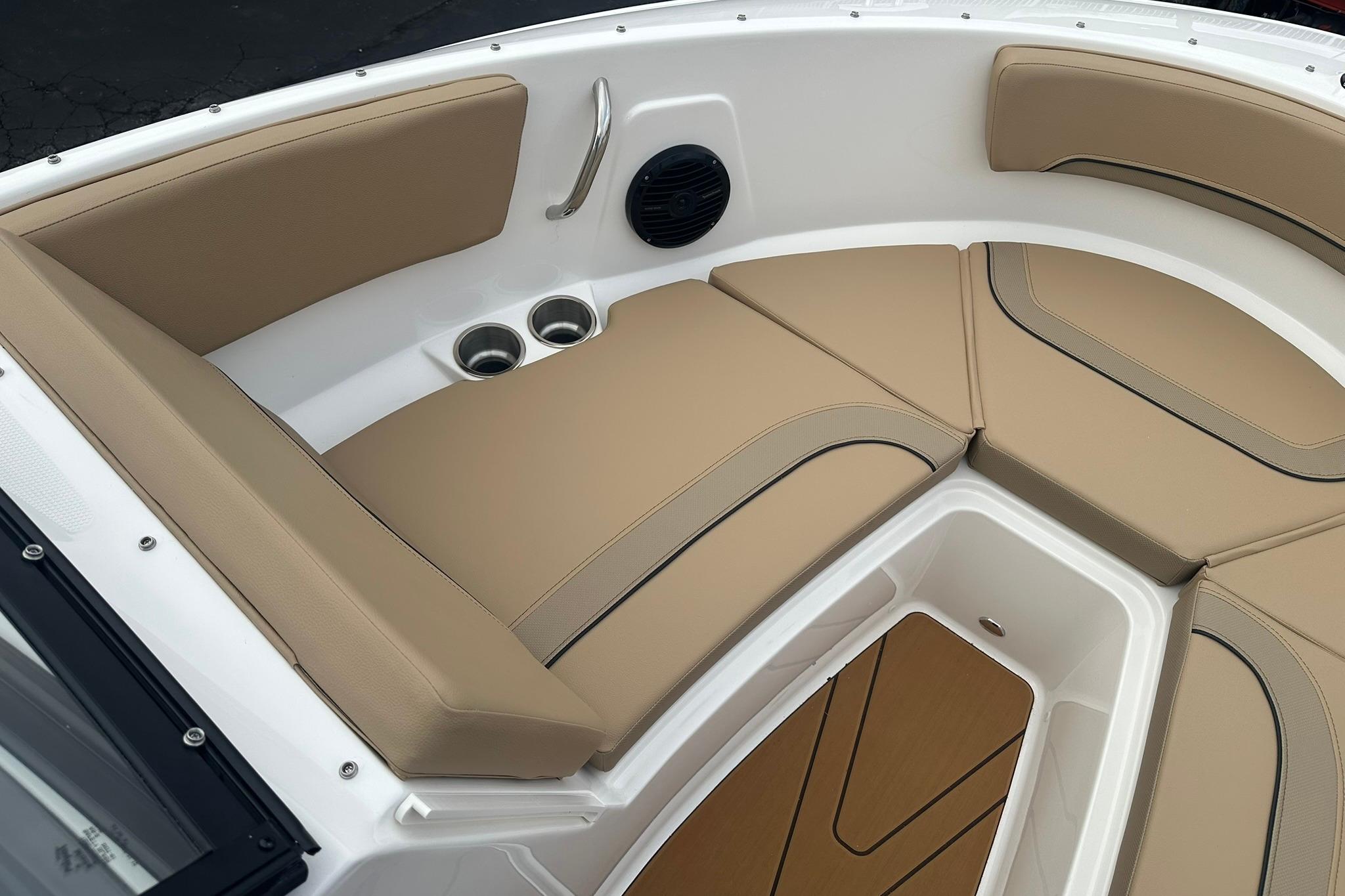 2026 Bayliner V20 boat interior with tan cushioned seating and cup holders.