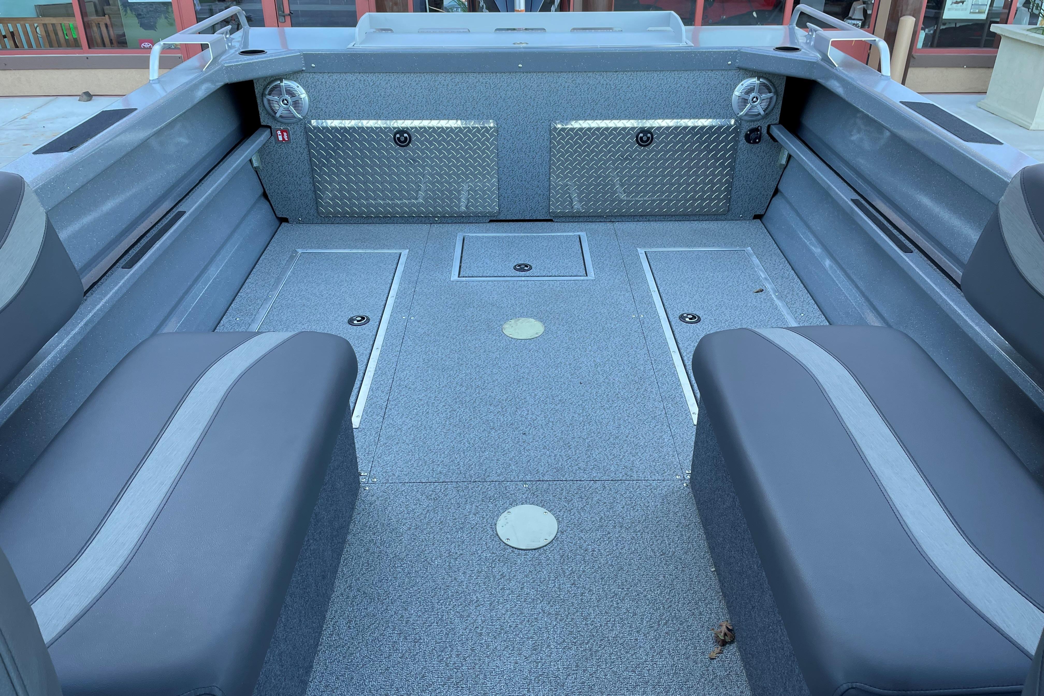 Interior of 2025 Spartan 200 Astoria boat with gray seating and storage compartments.