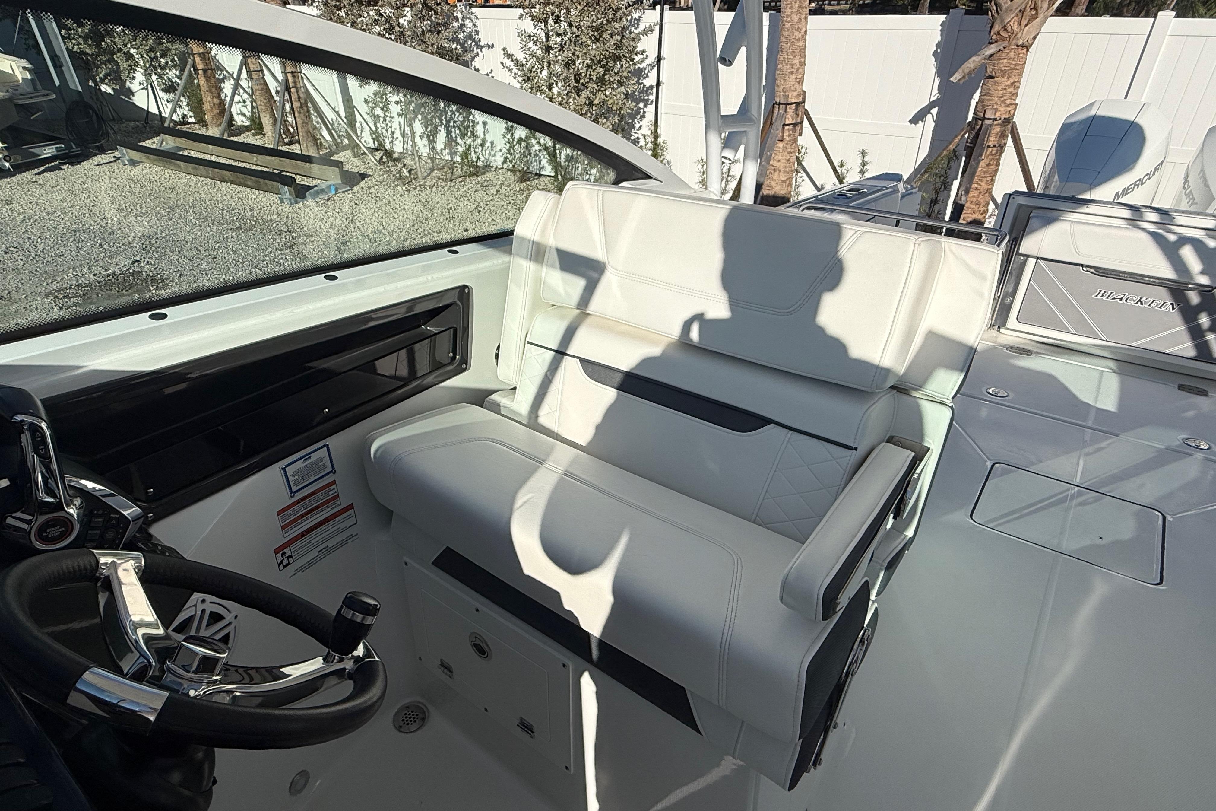 2022 Blackfin 272 DC boat interior with steering wheel and seating area.