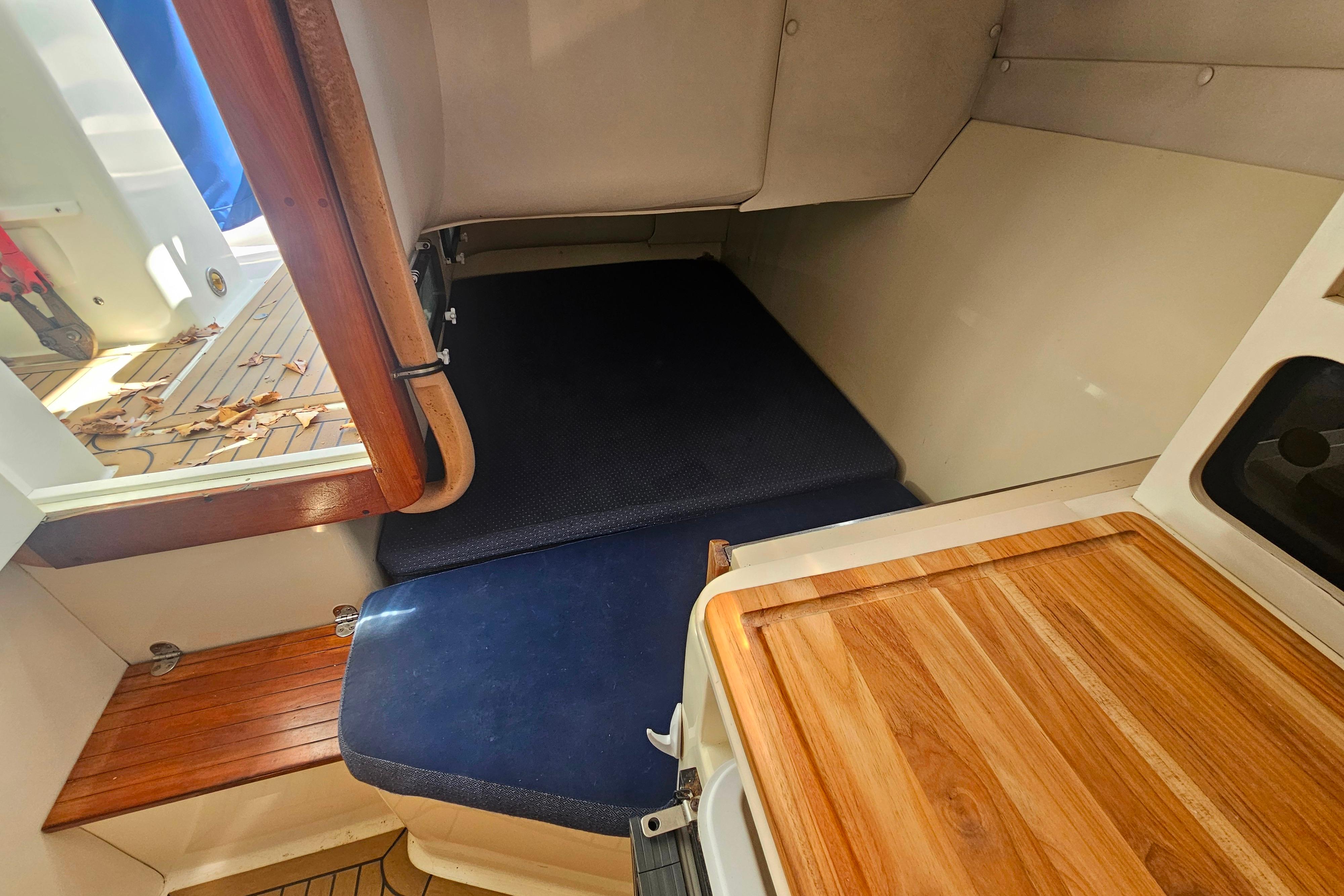 Interior cabin of 1999 Albin 28 Tournament Express with wooden and cushioned surfaces.